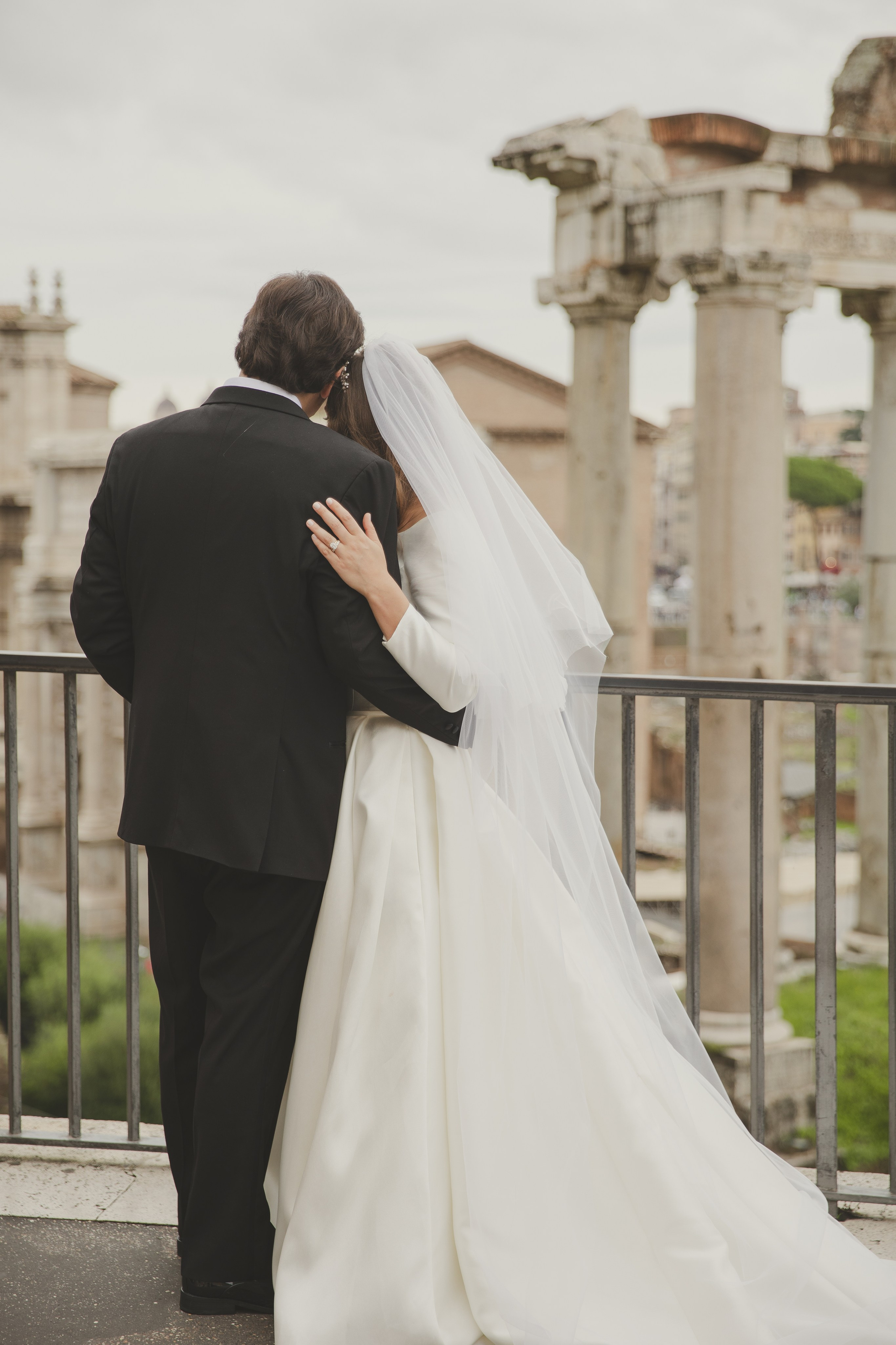 Newly married couple admiring the Roman Forum from a romantic viewpoint.
