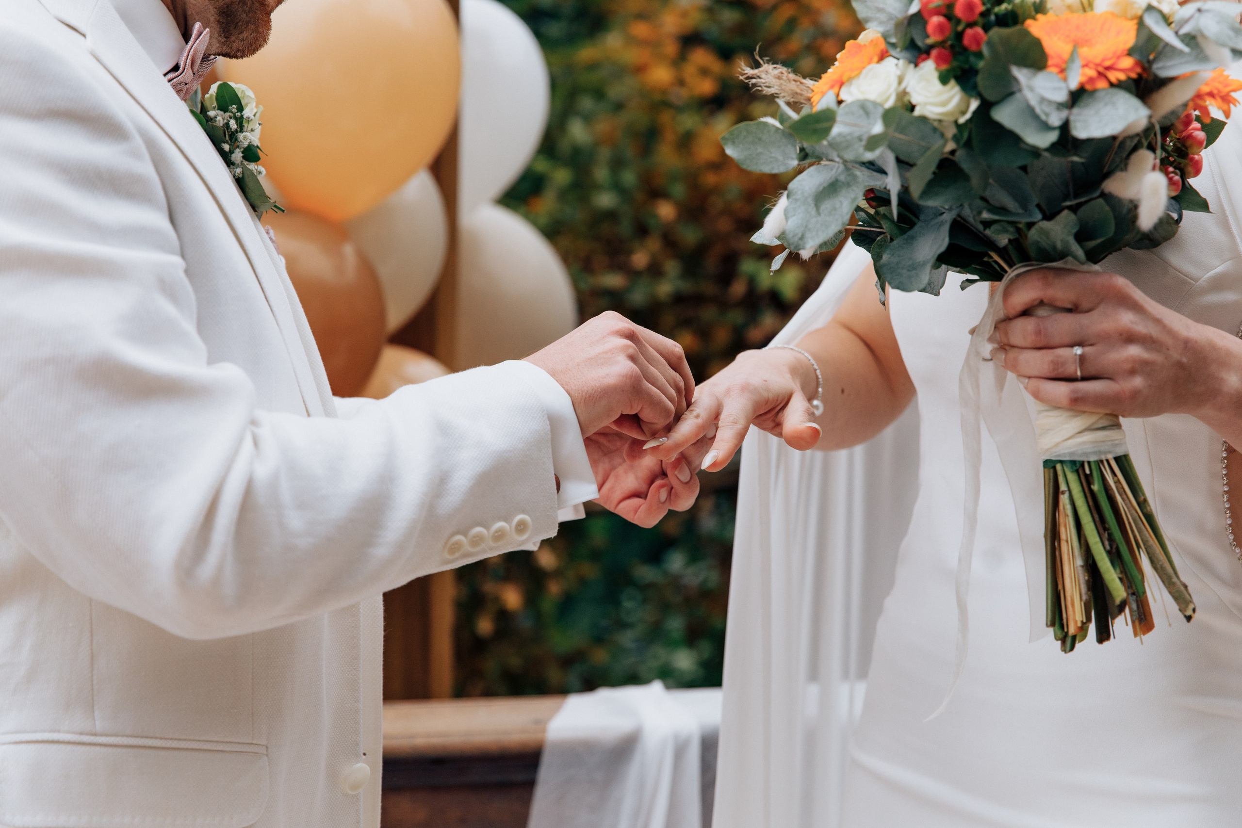 Der Bräutigam steckt der Braut den Ring an.