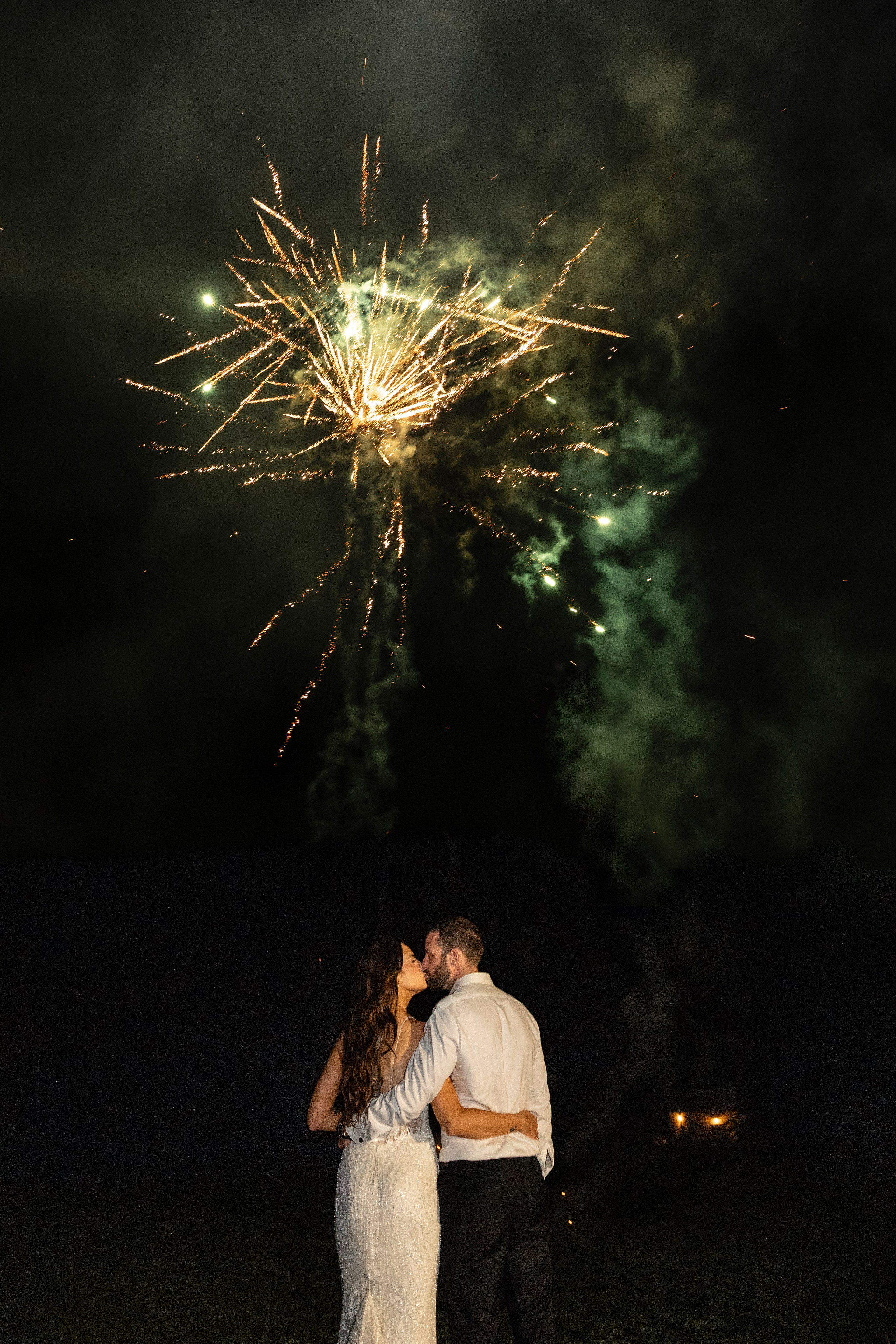 Bride and groom watching fireworks in the courtyard of Château Lagut, Dordogne.