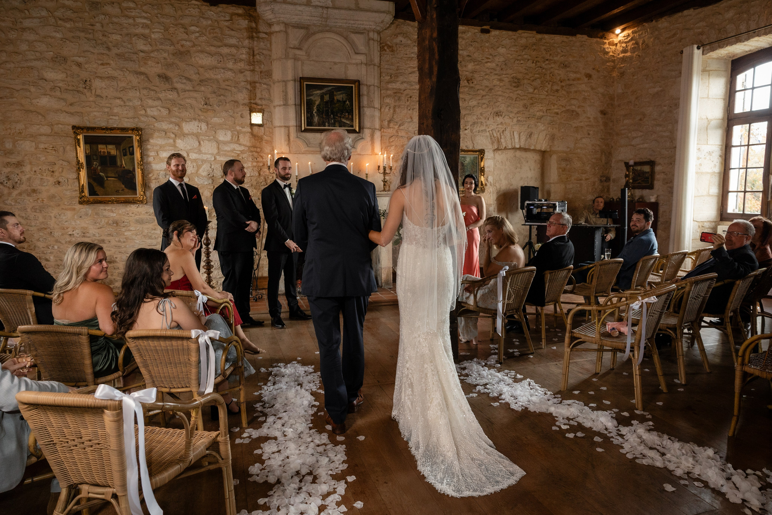 Indoor wedding ceremony at Château Lagut with candlelight and fireplace backdrop.