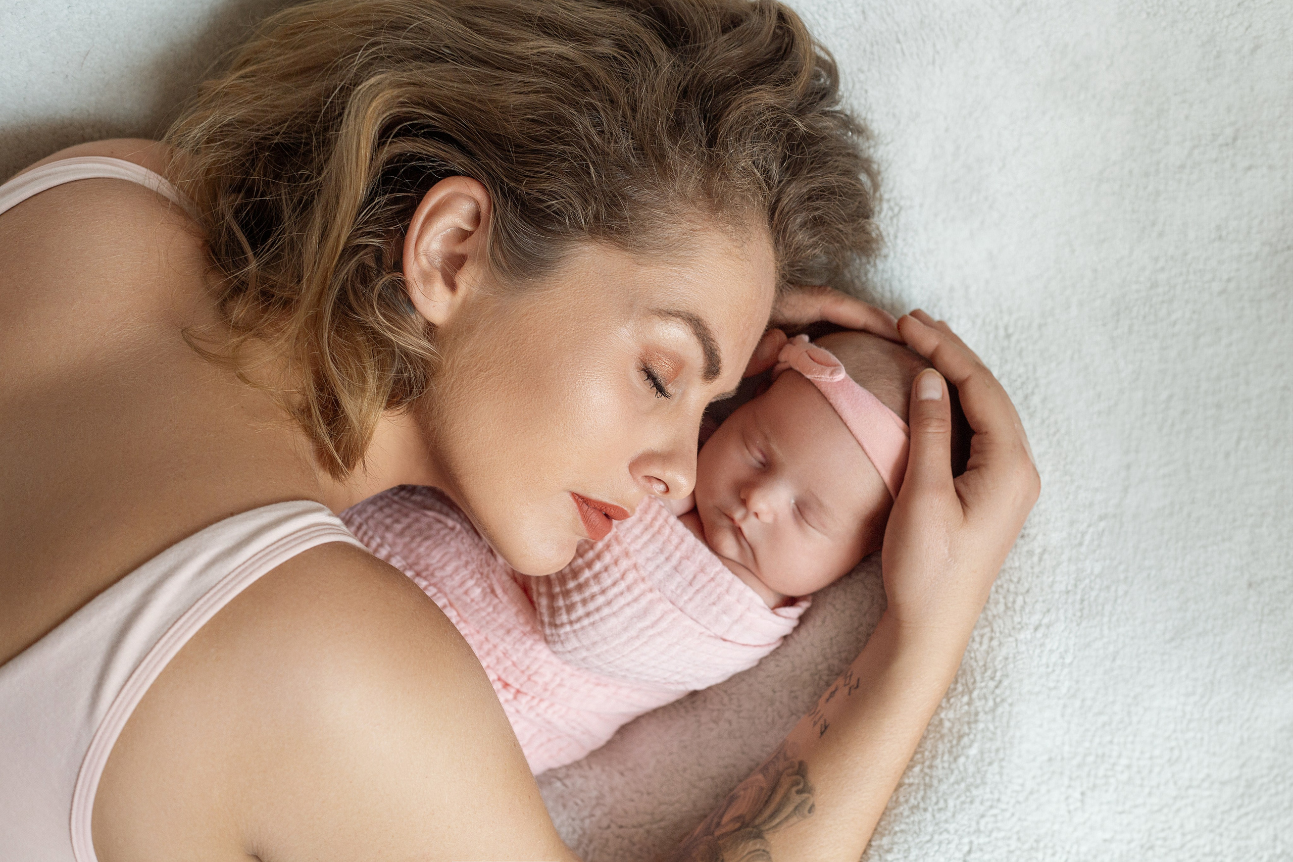 Câlin doux entre maman et bébé, moment intime capturé lors d'une séance photo nouveau-né