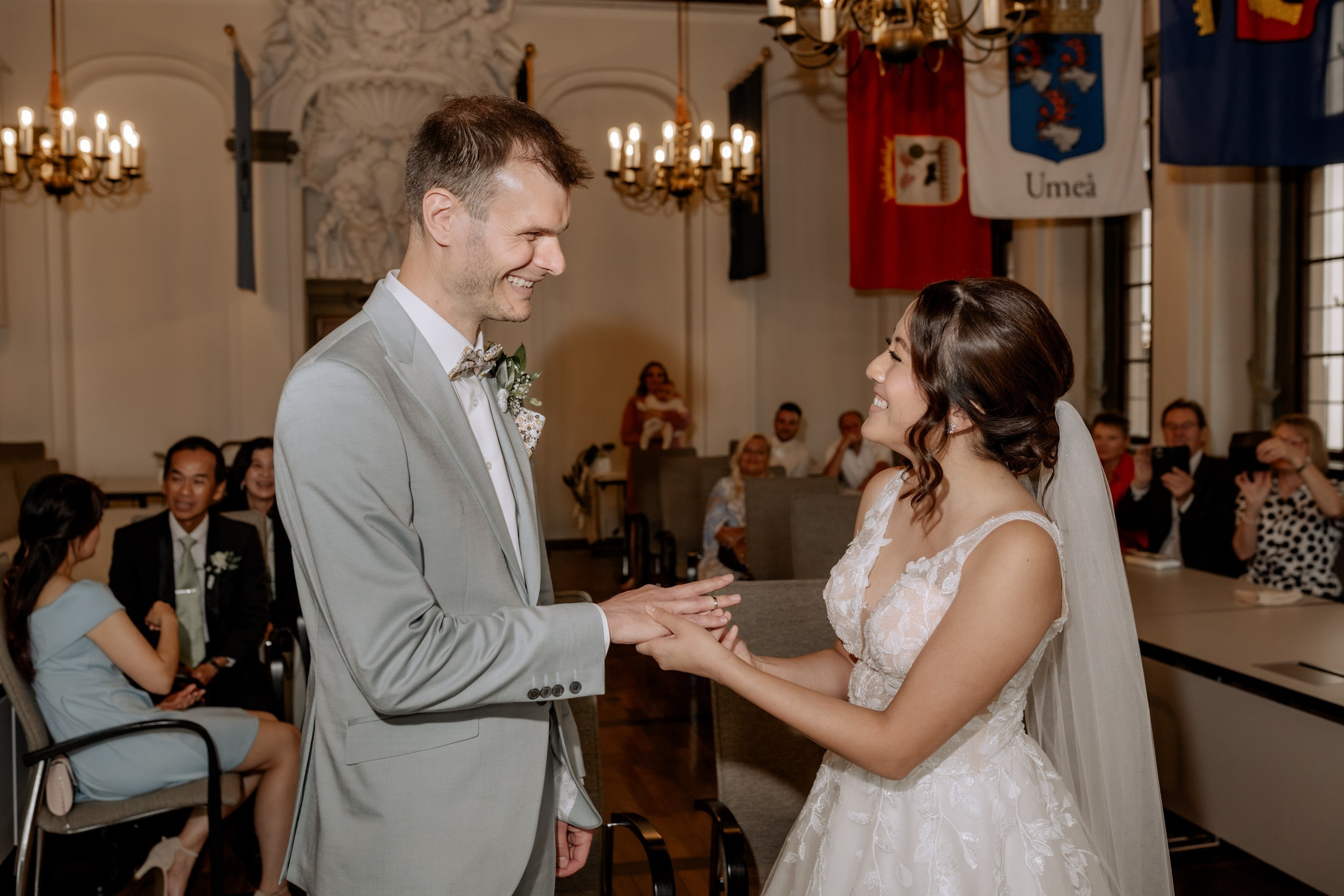 Das Brautpaar steht Hand in Hand im Trausaal des Standesamts Würzburg. Historische Holzstühle und ein warmes, weiches Licht umrahmen den feierlichen Moment.