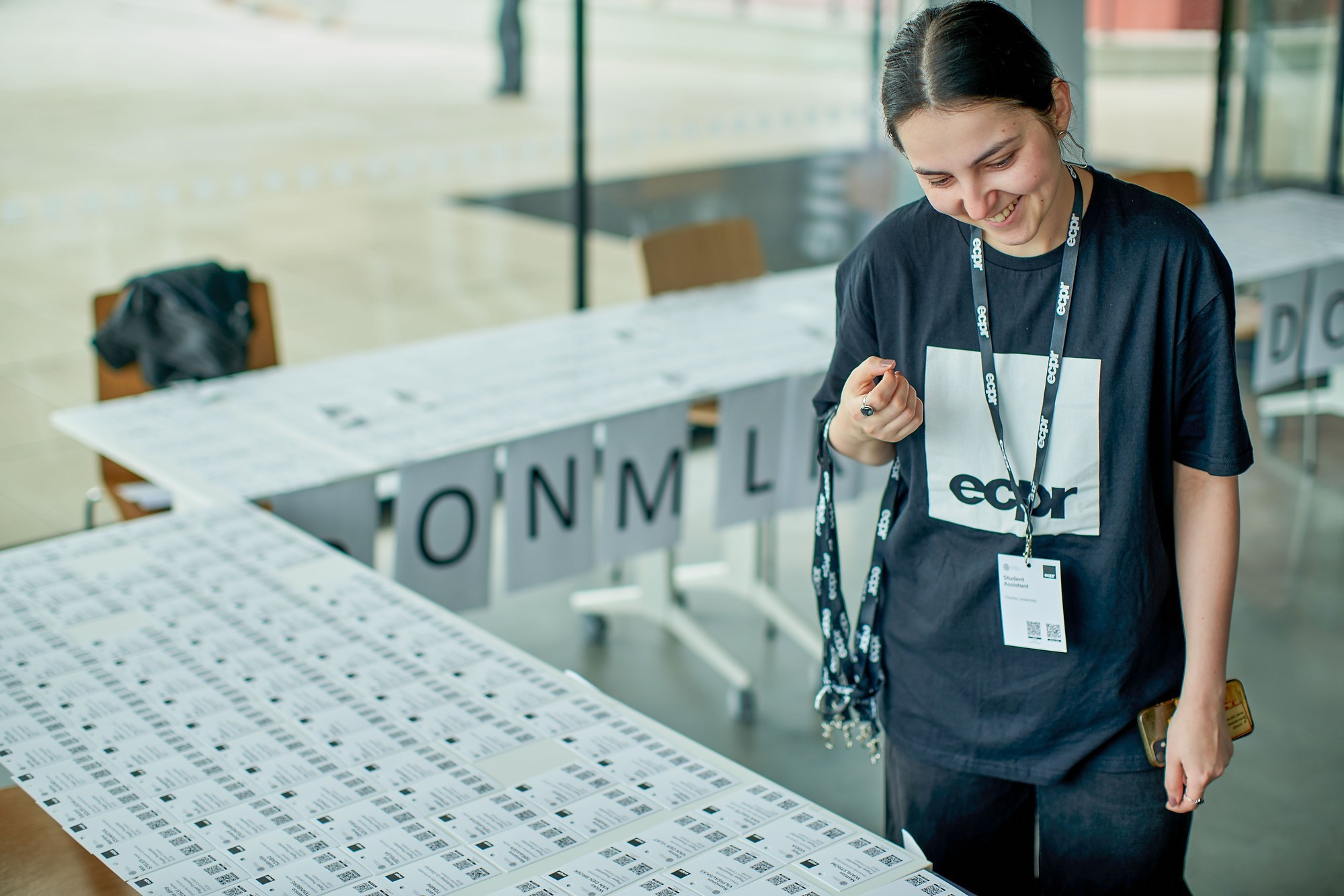 An employee checks to ensure all names have been printed and laid out for attendees of an ECPR Political Research Conference held in Prague, May 2025, at Charles University.