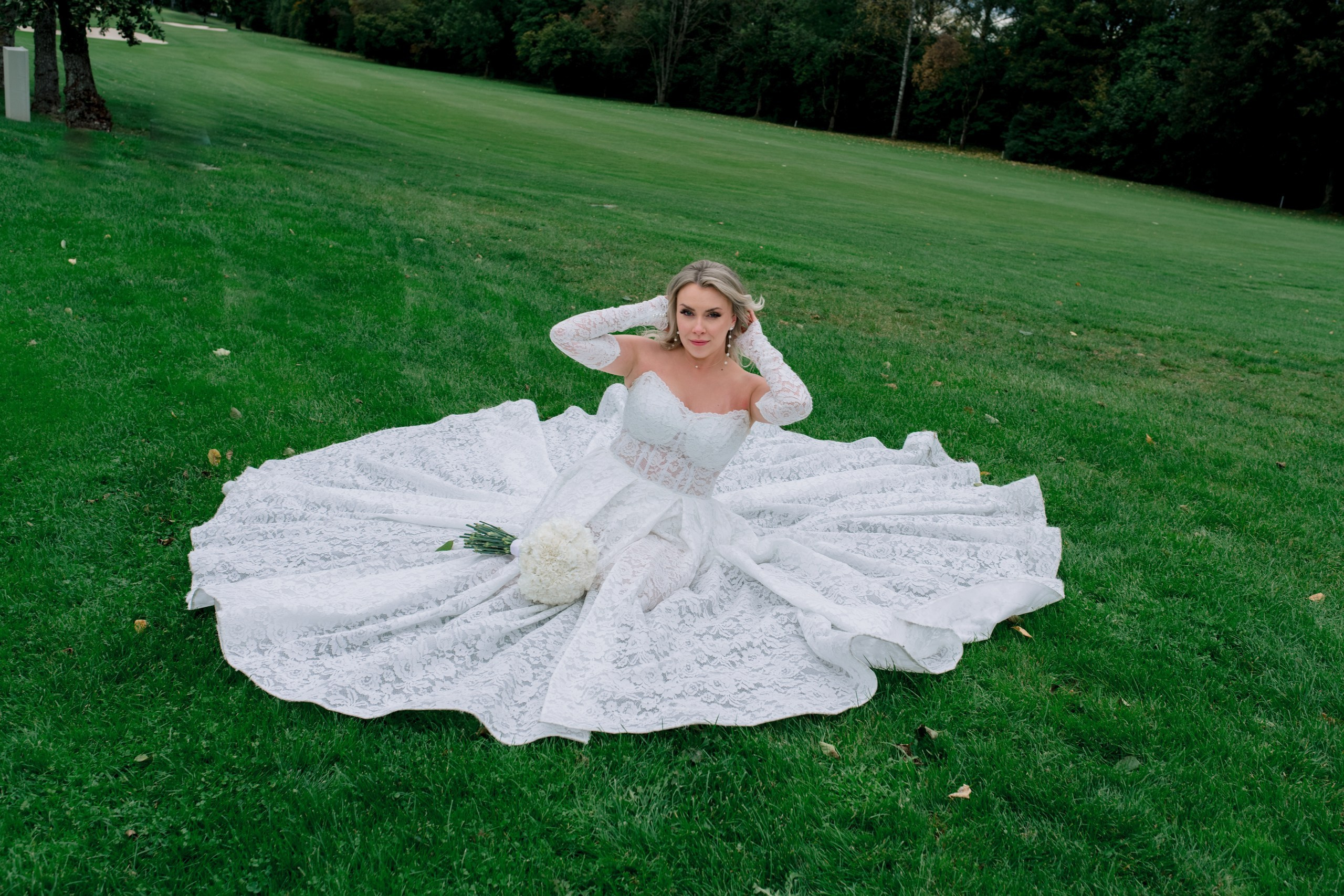 Detailaufnahme: Brautkleid weht im Wind auf dem Rasen – Hochzeit in Augsburg