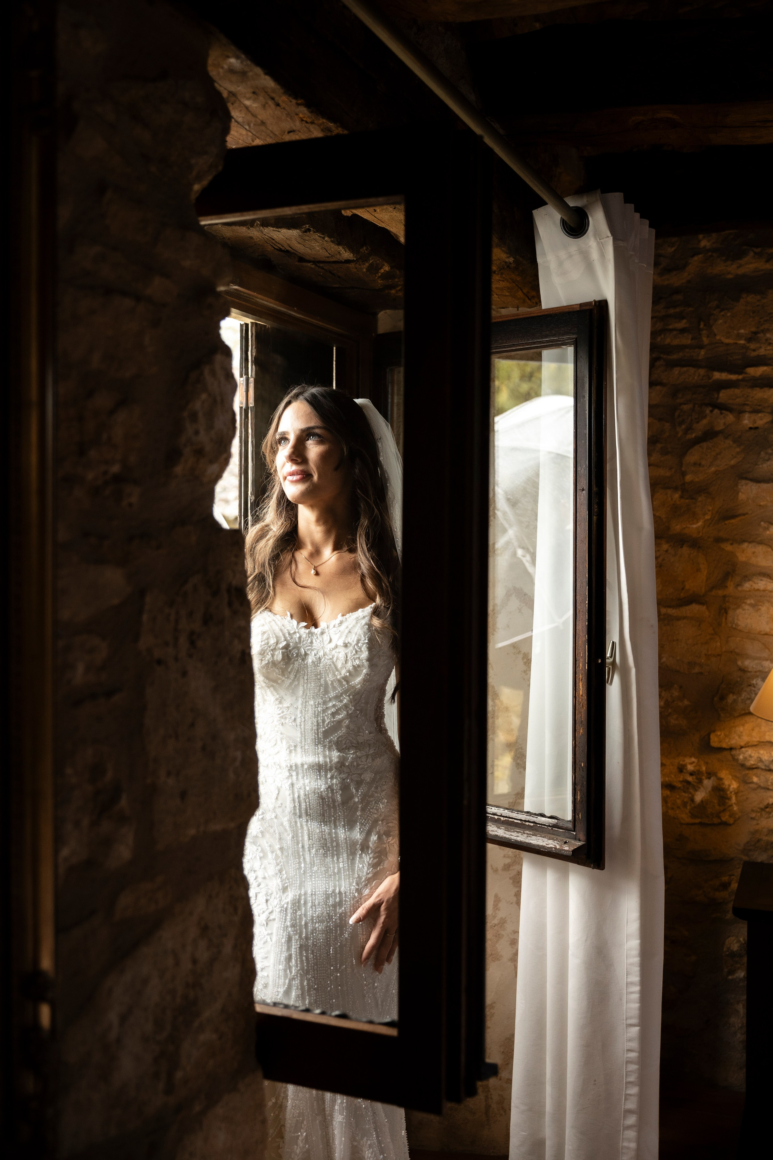 Bride walking inside Château Lagut before rainy-day ceremony.