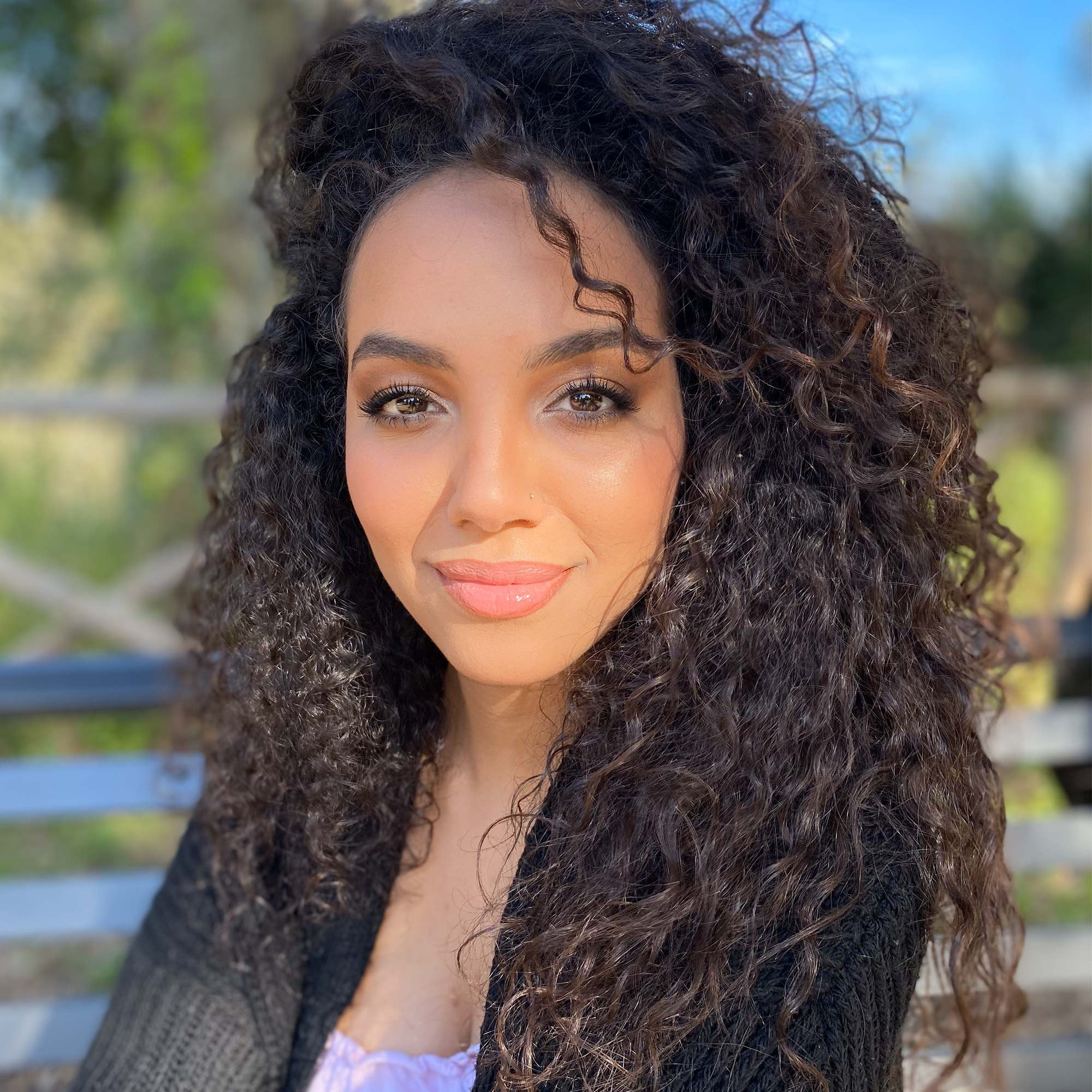 arabic girl with a big curly hair and professional makeup in a park in rome