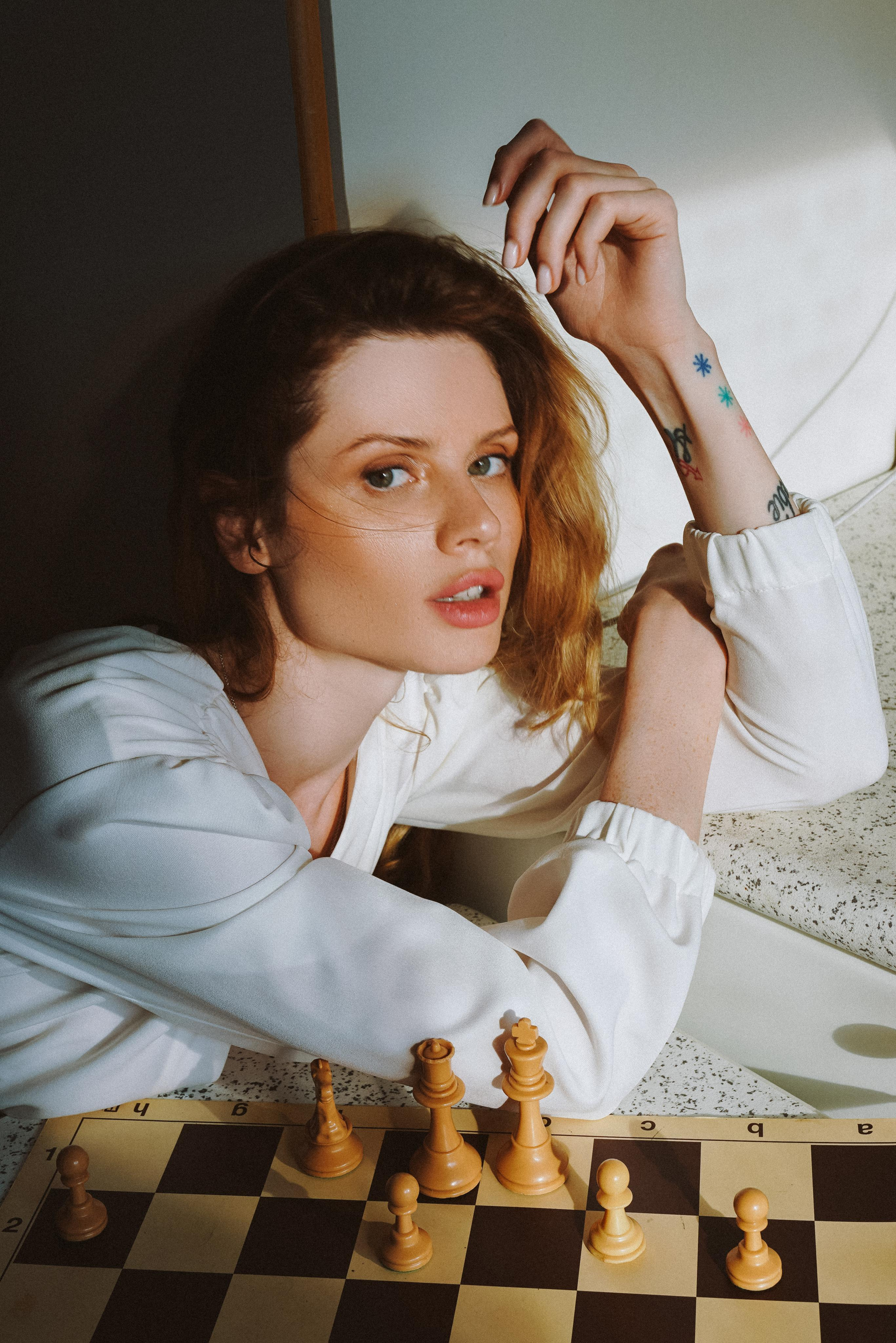 a model with bronze makeup posing in front of a chess board
