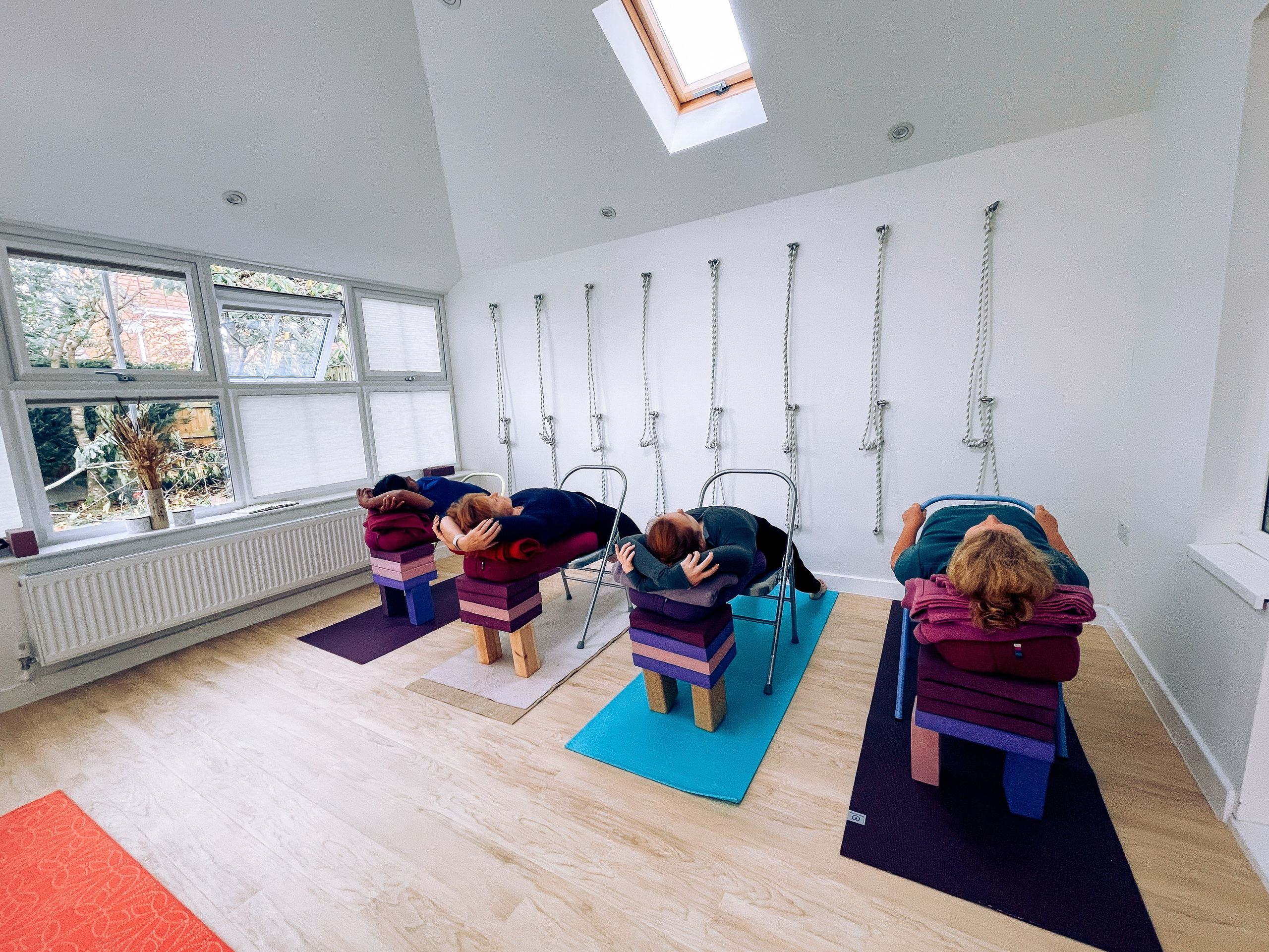 Four Iyengar yoga students in Purvottanasana supported