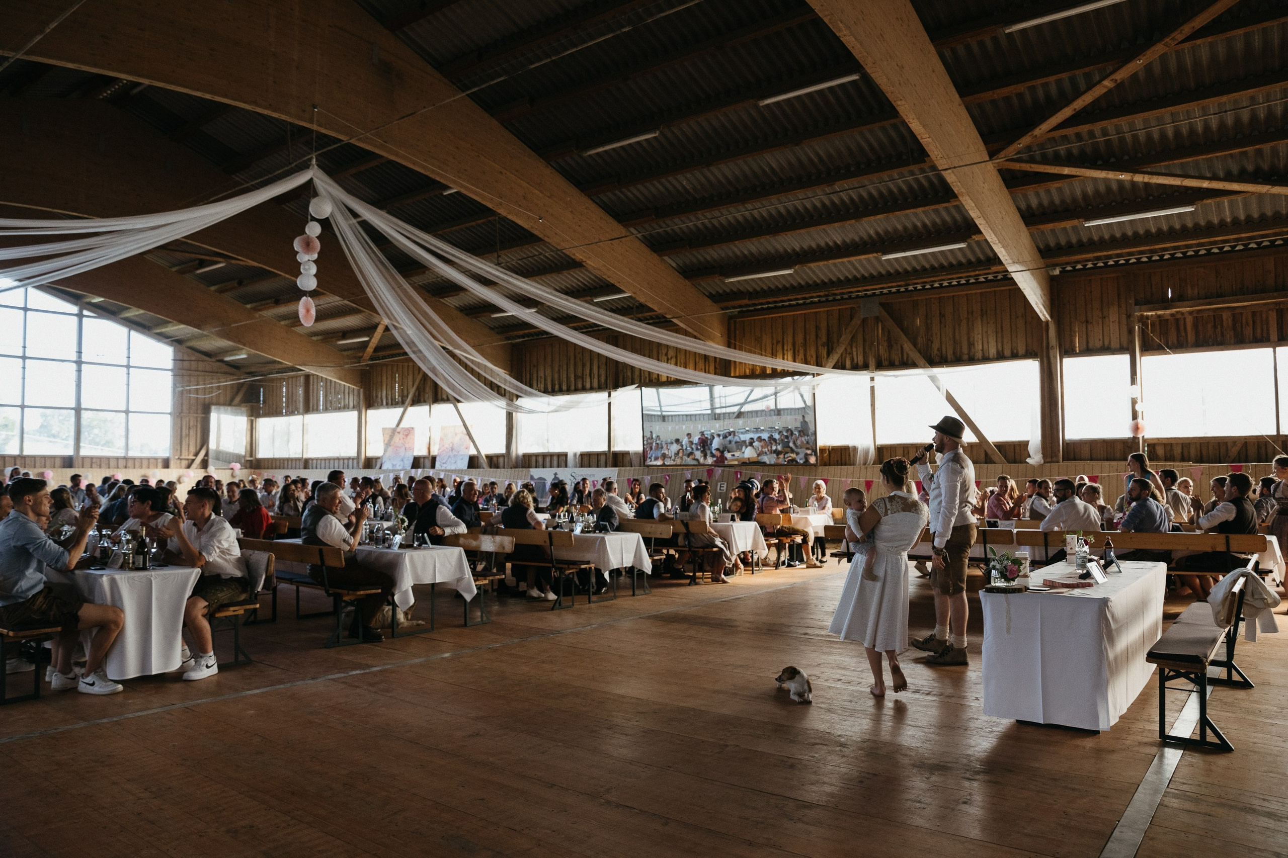Hochzeitsfeier in dekorierter Scheune mit Gästen, Süddeutschland