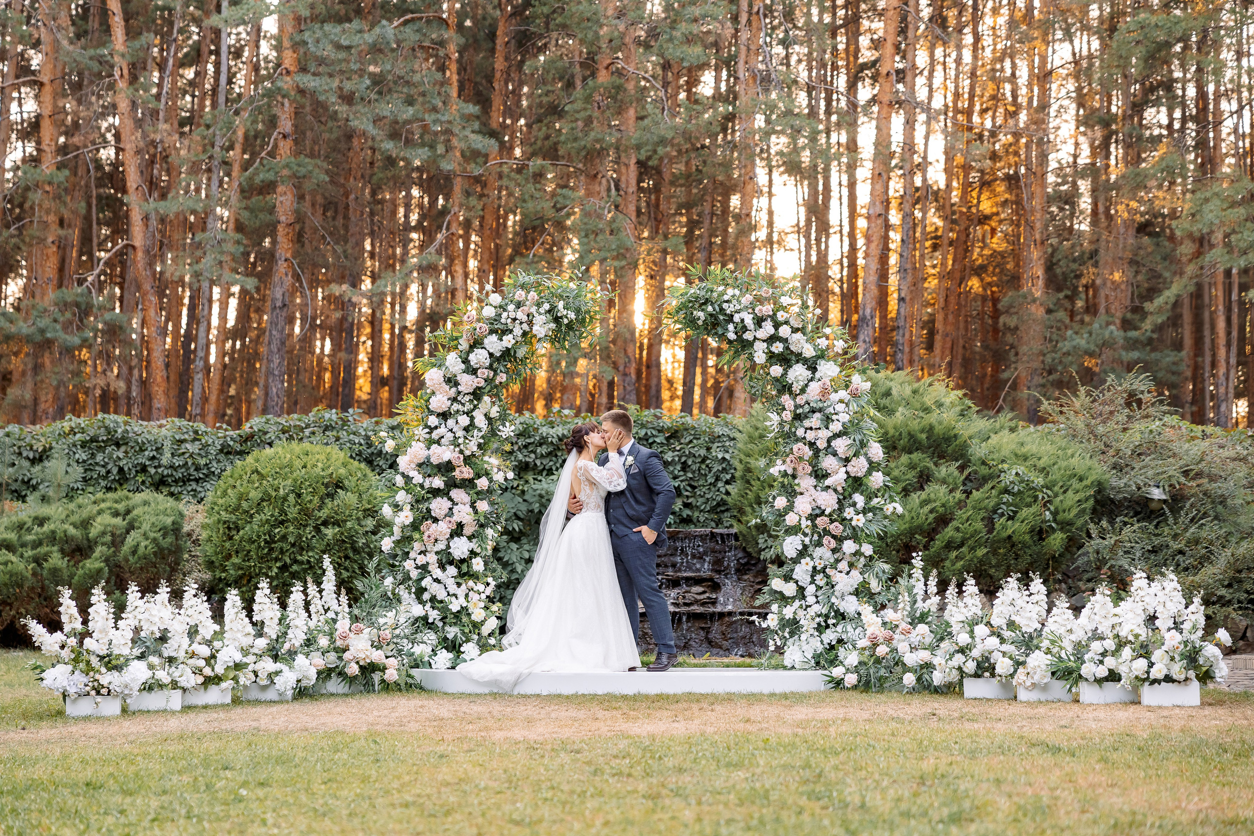 Freie Trauung im Wald mit einer großen Blumenarkade | Hochzeitsfotograf für ganztägige Hochzeitsreportagen in NRW: Bochum, Dortmund, Essen, Düsseldorf, Duisburg, Wuppertal, Krefeld, Gelsenkirchen, Oberhausen, Münster, Köln, Bonn, Aachen, Bielefeld, Hamm, Mülheim an der Ruhr, Düren, Siegen, Solingen, Paderborn, Herne, Moers, Recklinghausen, Leverkusen, Marl, Dülmen, Velbert, Ratingen, Lüdenscheid, Castrop-Rauxel, Gladbeck, Unna, Hattingen, Herten, Wesel, Bergkamen, Lippstadt, Troisdorf, Viersen und Umgebung.