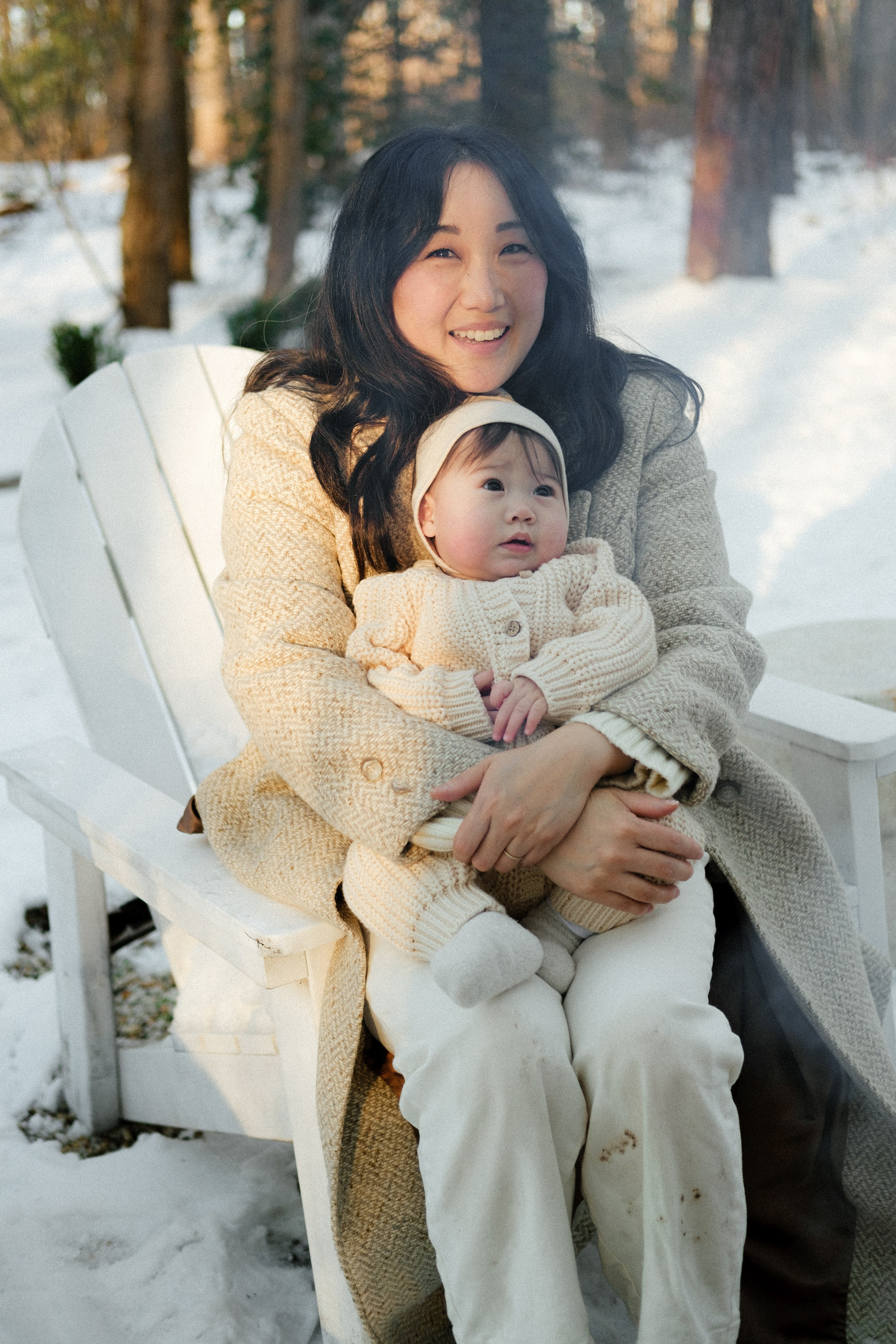 Mom and baby daughter are sitting by the fire during the winter afternoon in Richmond, VA