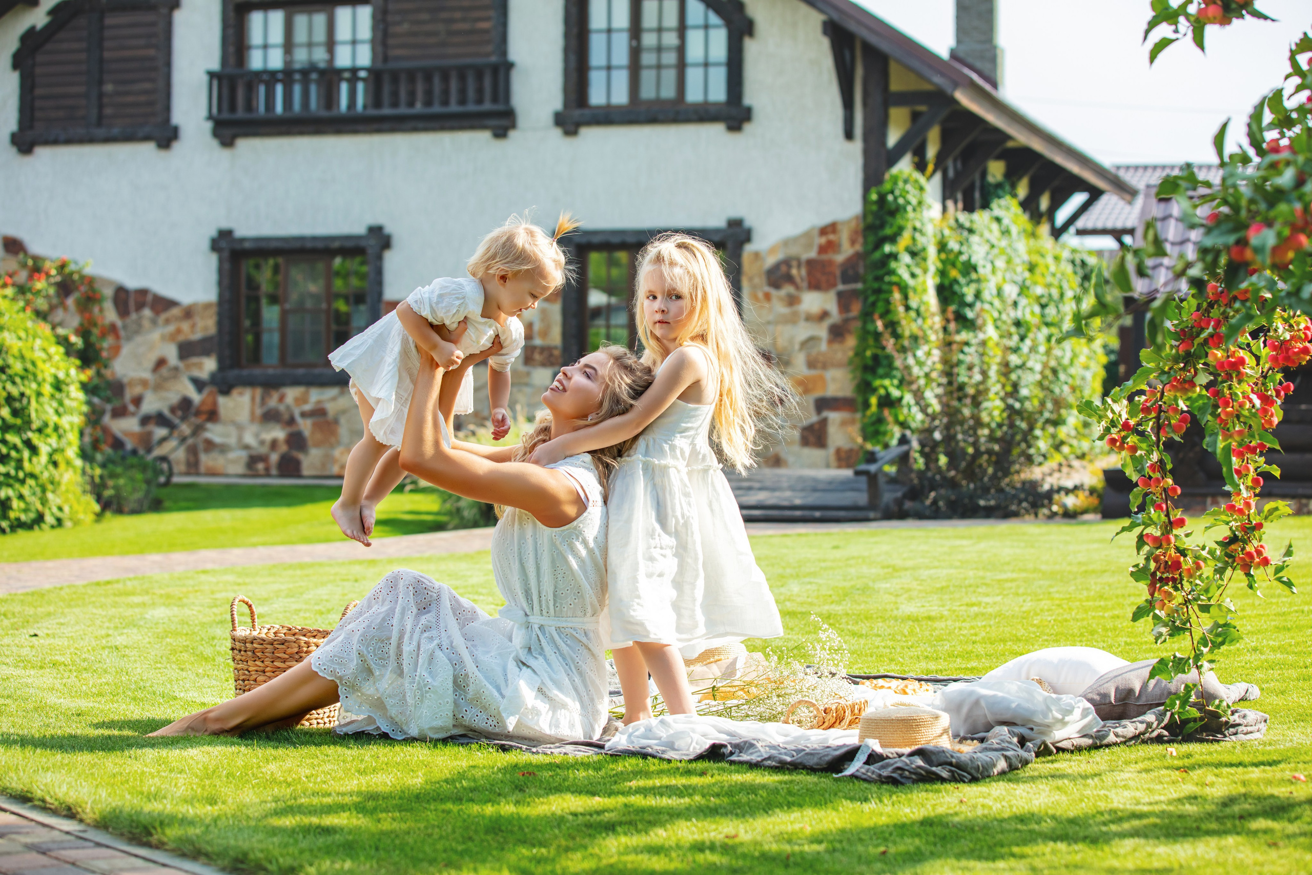 Séance photo familiale devant la maison avec maman, enfant et chien, ambiance joyeuse