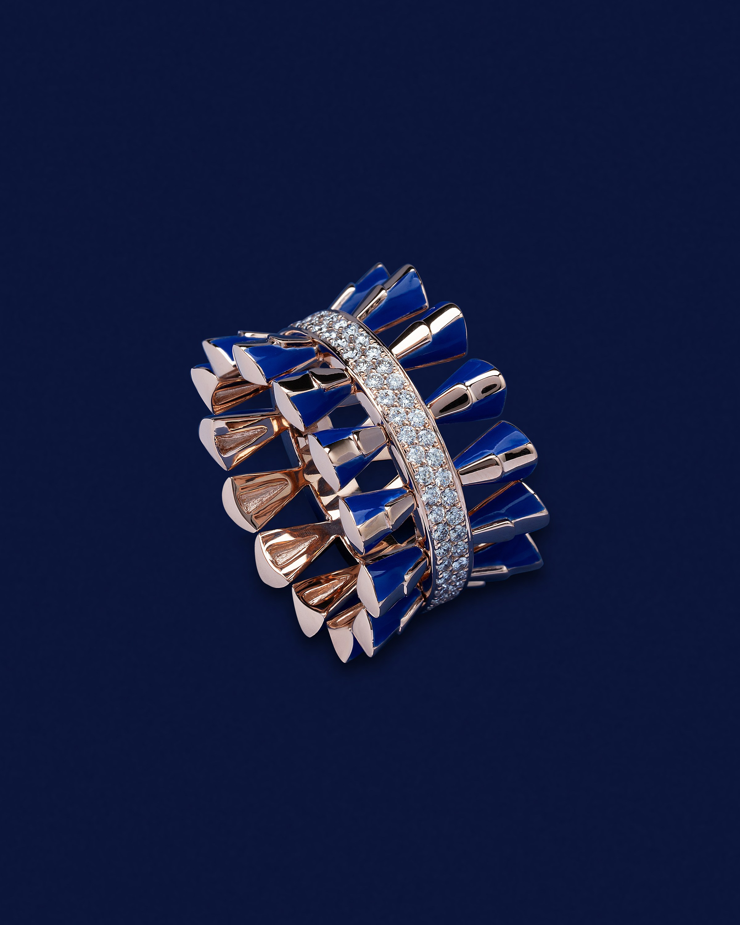 Elegant gold ring with blue enamel inlays and a diamond band on a dark blue background