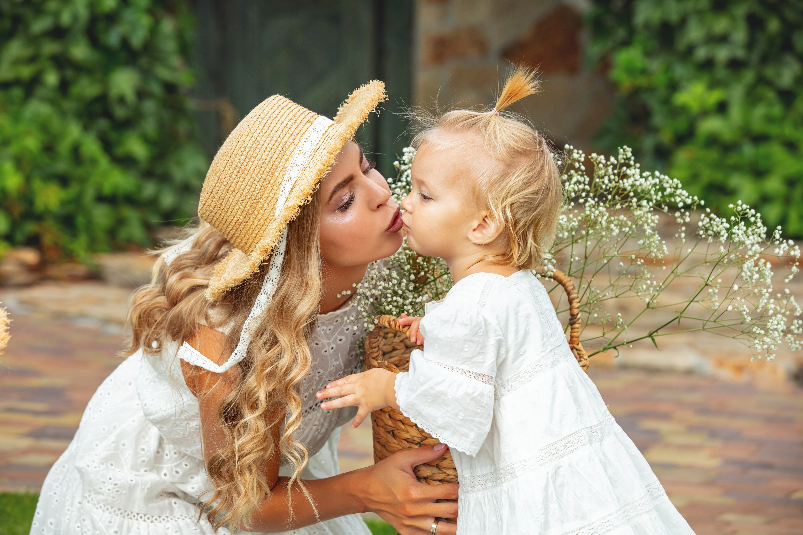 Maman embrassant tendrement son enfant pendant une séance photo de famille en été