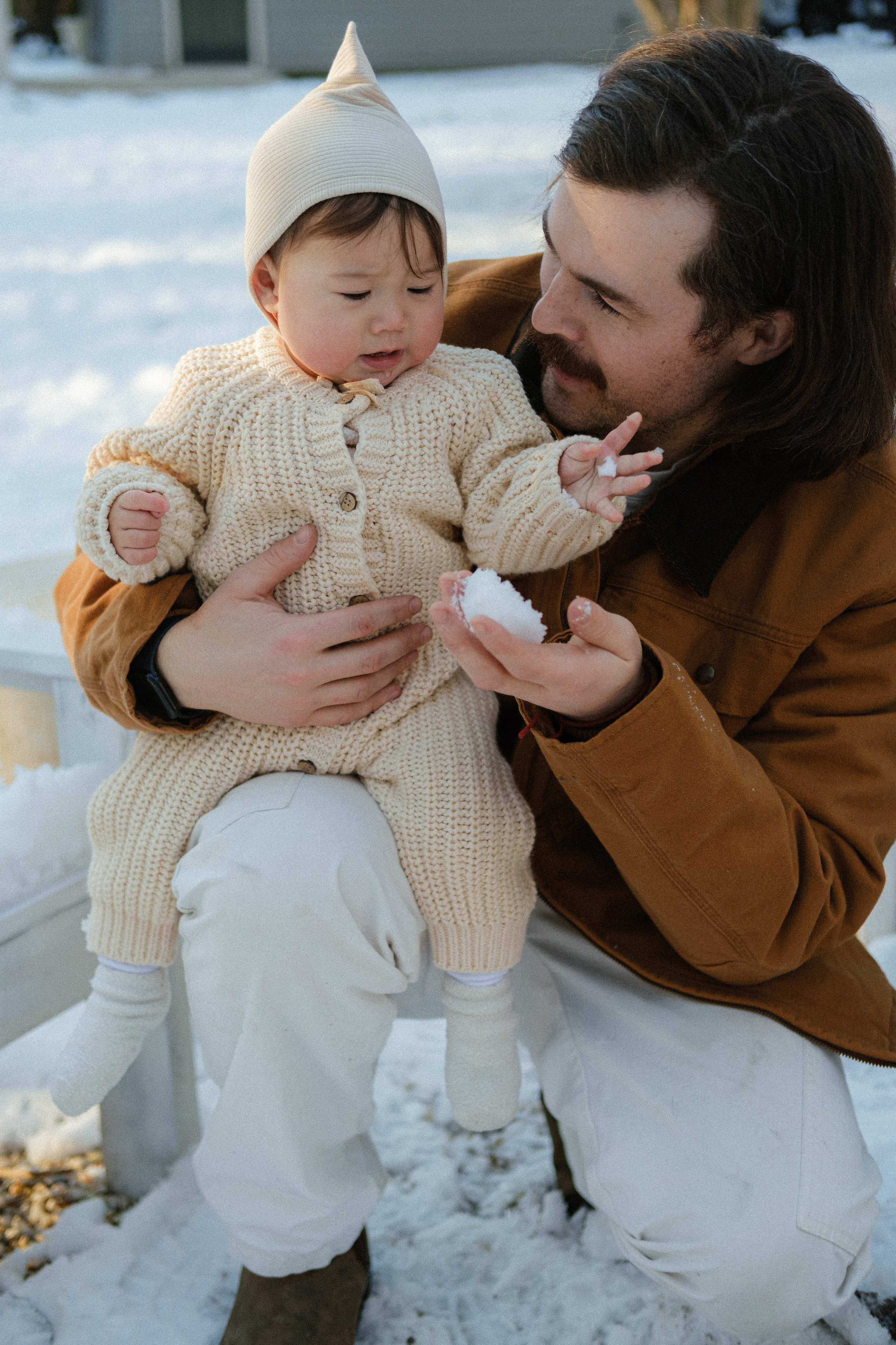Dad is giving his baby daughter to touch snow for the first time in her life in Richmond, VA