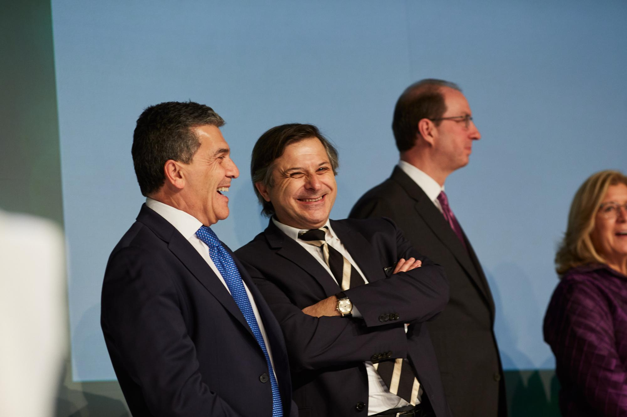 Bio-Rad executives share a laugh while they stand on stage during an award presentation.