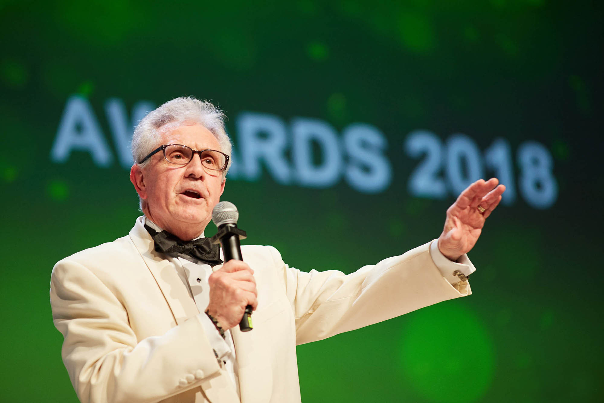 Executive in white suit speaking at Bio-Rad gala, Hilton Prague.