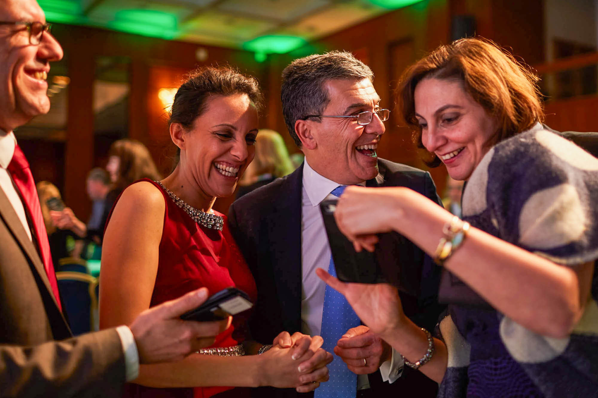 Guests reacting to photo booth print at gala, Prague.