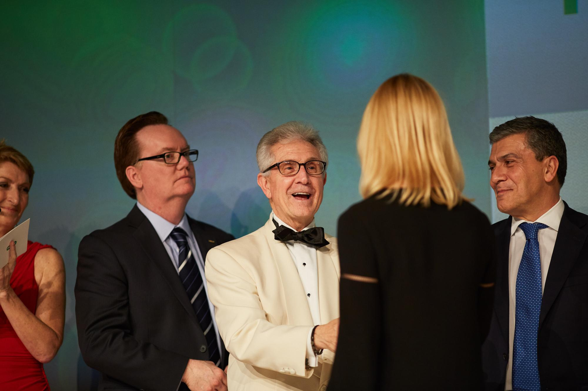 Awardees receive congratulations on stage.