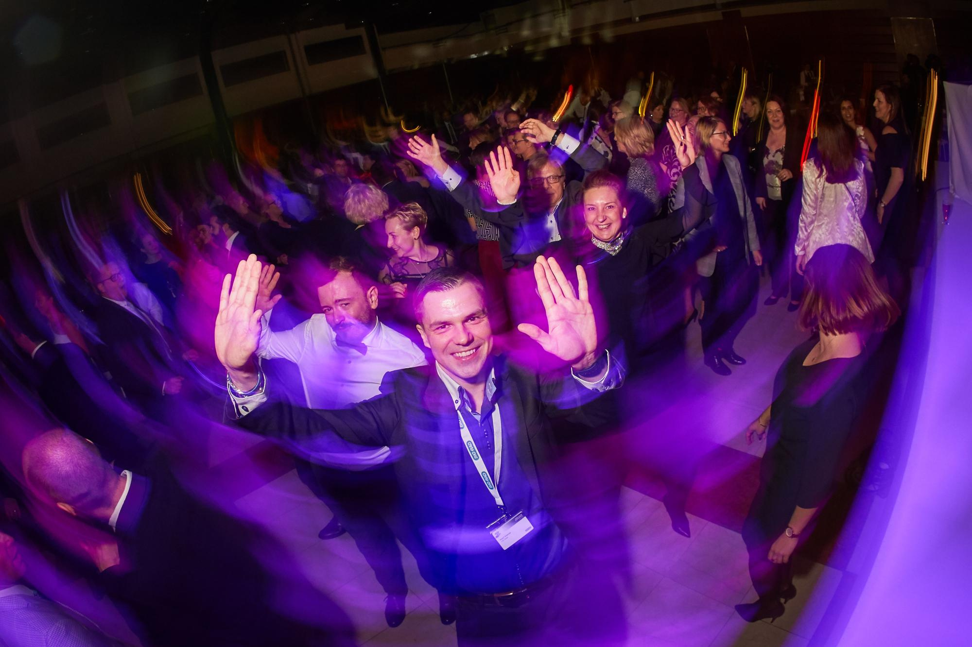 A Bio-Rad employee waves from the dance floor during the evening festivities in Prague.