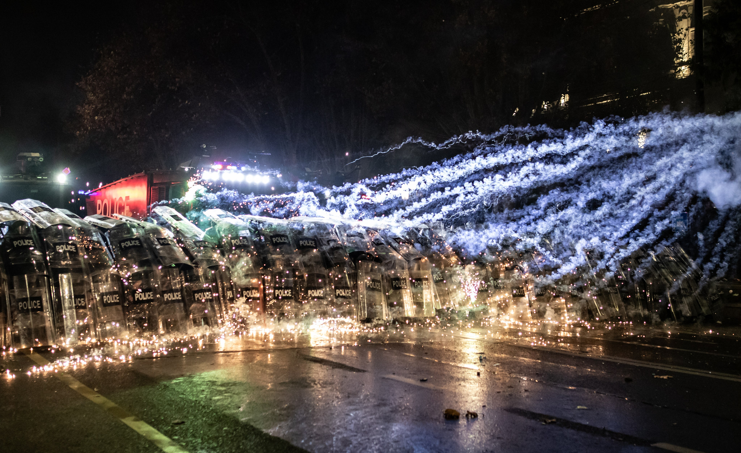 Les manifestants tirent des feux d’artifice sur les forces de l’ordre, protégées par leurs boucliers devant le Parlement.