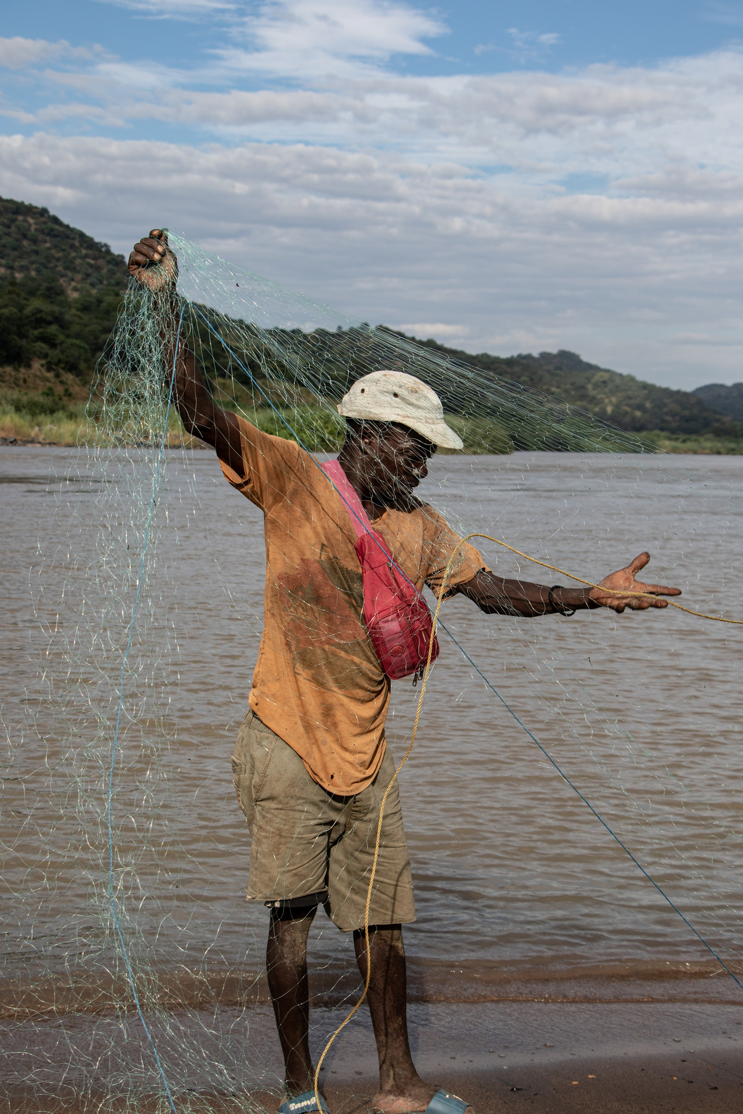Alexandre le pêcheur nettoie son filet sur les rives du Zambèze, un fleuve dont dépend toute sa subsistance. La pêche artisanale est essentielle pour nourrir les familles de la région. Le projet du barrage Mphanda Nkuwa menace de perturber l’écosystème fluvial, compromettant l’abondance des poissons et la survie de cette activité traditionnelle.