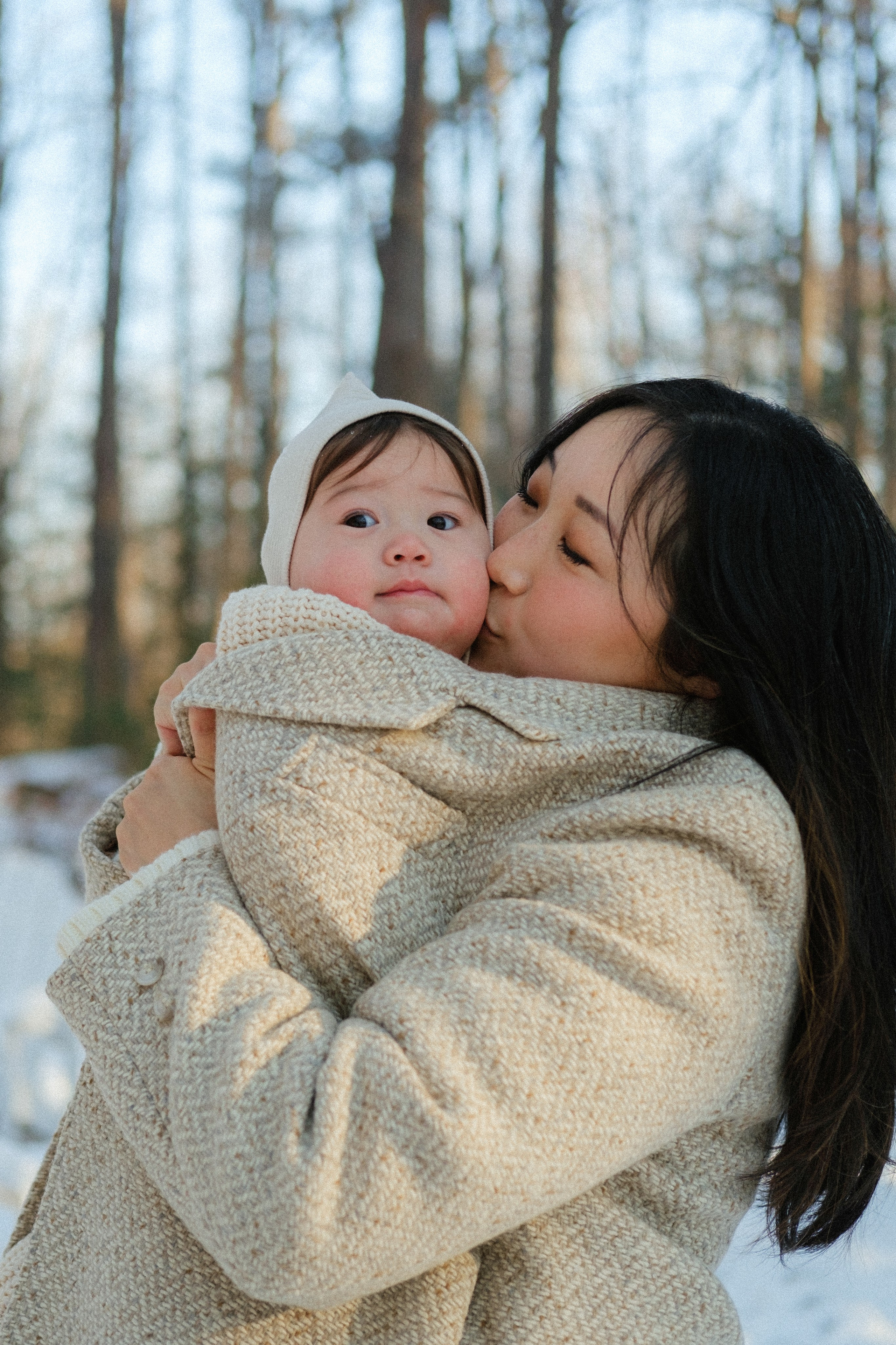 Mom wrapping her child in a wool coat in snowy Richmond, VA — a tender winter moment full of love.