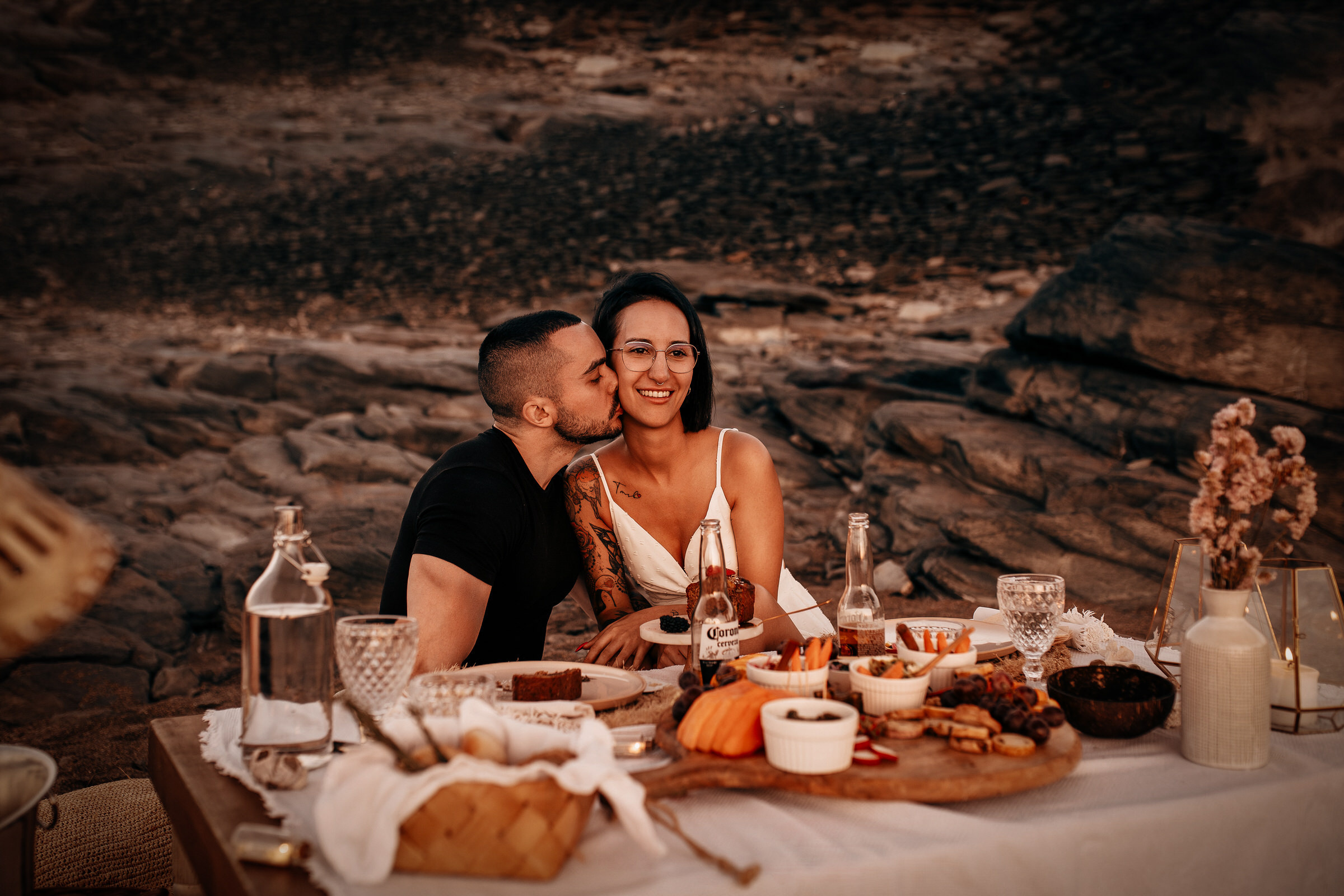 Pari suutelee pöydän ääressä autiolla rannalla Valokuvaus ammattivalokuvaajan kanssa Gran Canarialla