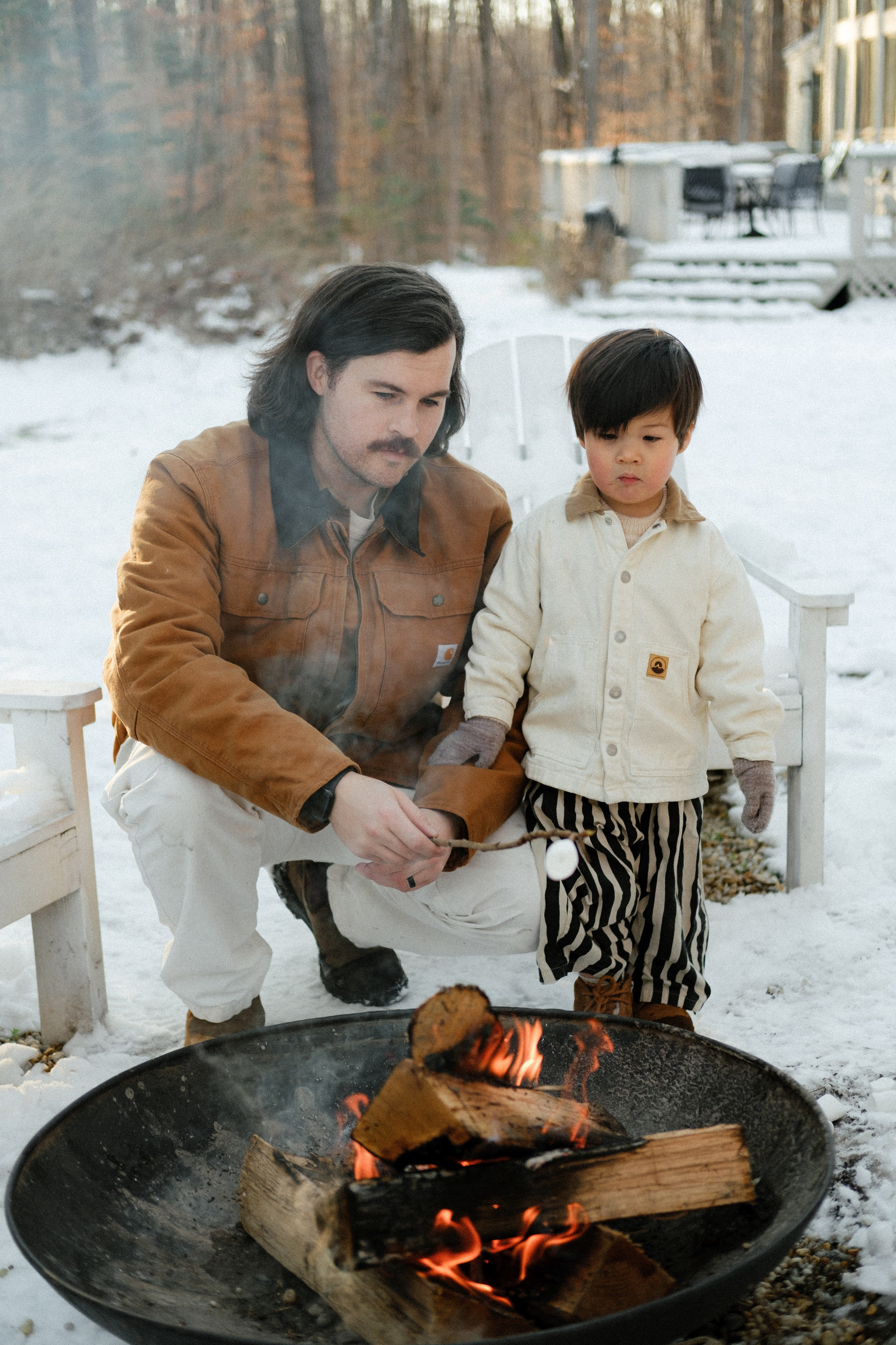 Dad helping the kids toast marshmallows by the fire in Richmond, VA — creating traditions under the winter sky.
