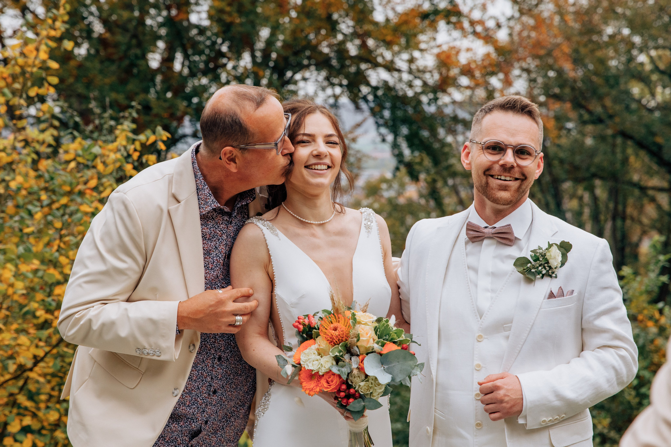 Der Onkel küsst die Braut auf die Wange.