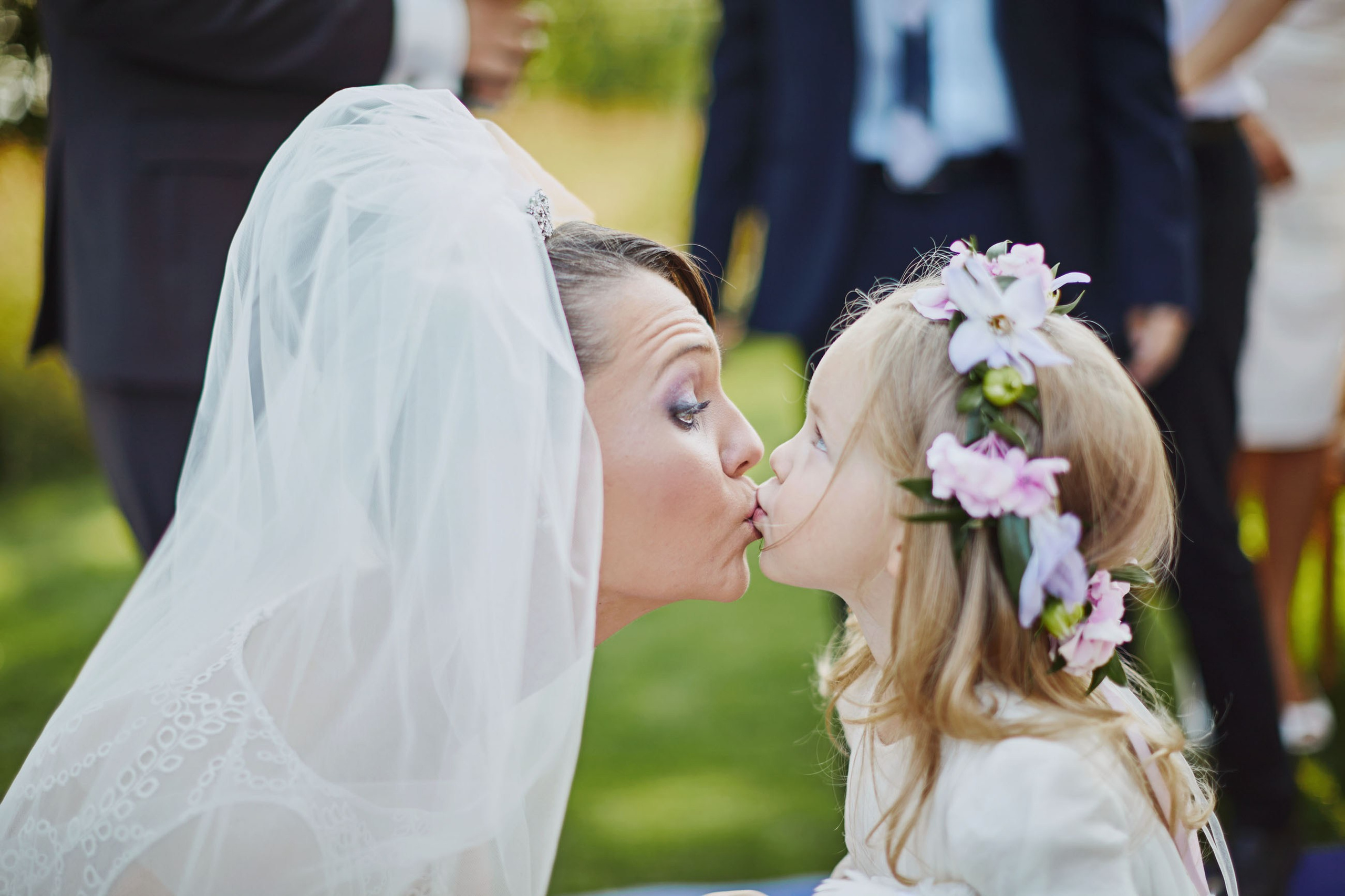 Bride kissing young flower girl after wedding at Chateau Mcely.