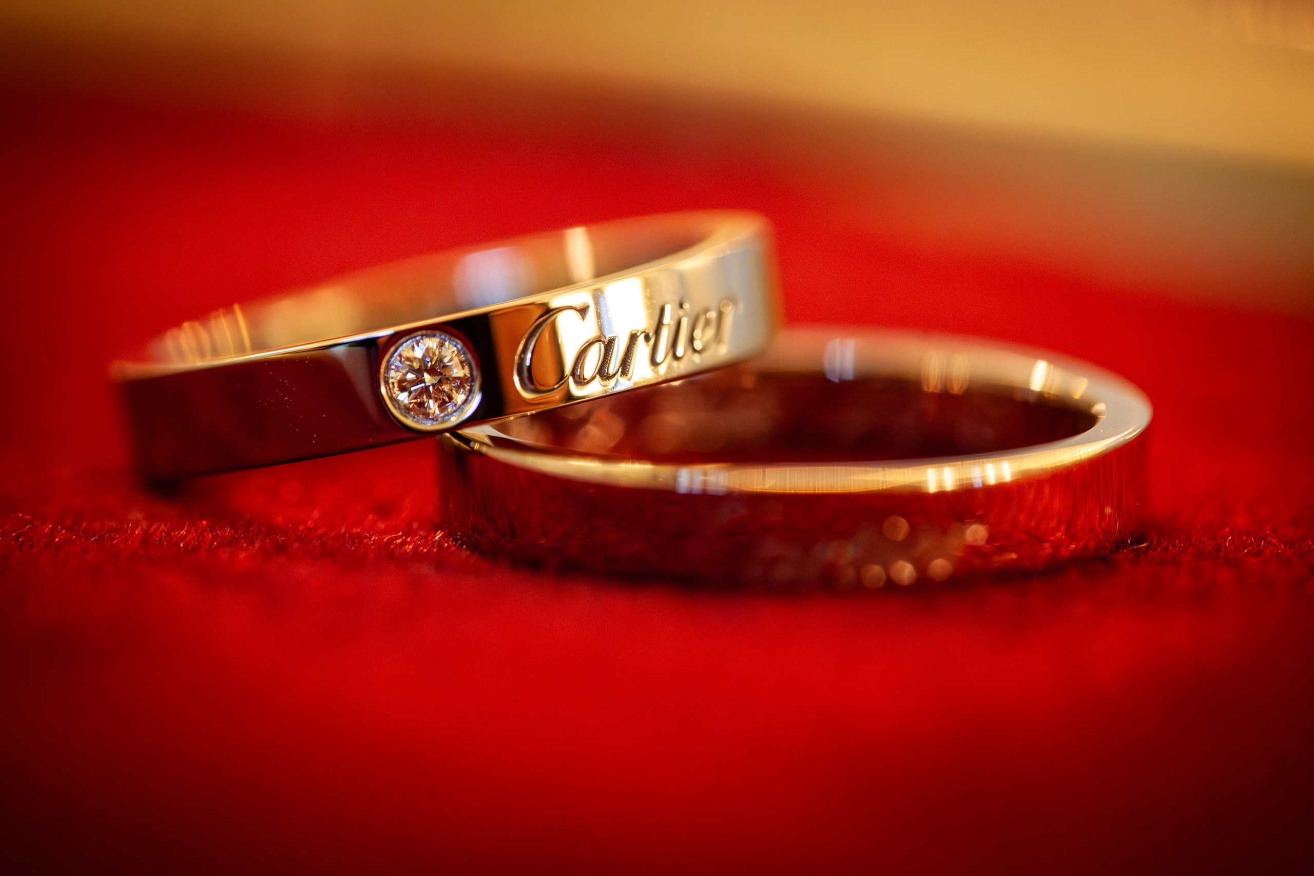 A pair of diamand encrusted Cartier wedding bands await the start of candlelit castle wedding ceremony.