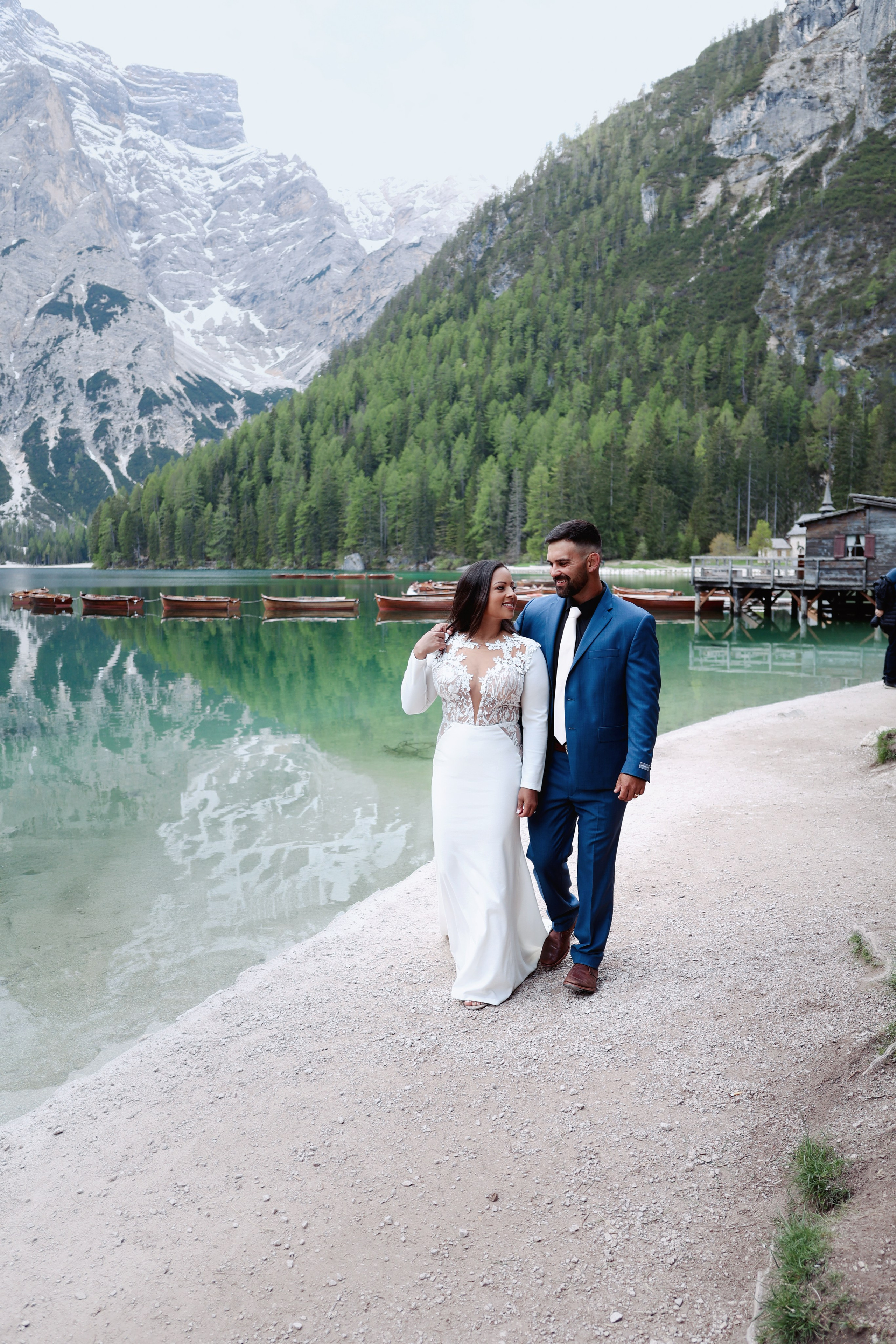 Bride and groom walking by Lake Braies during their Dolomites elopement