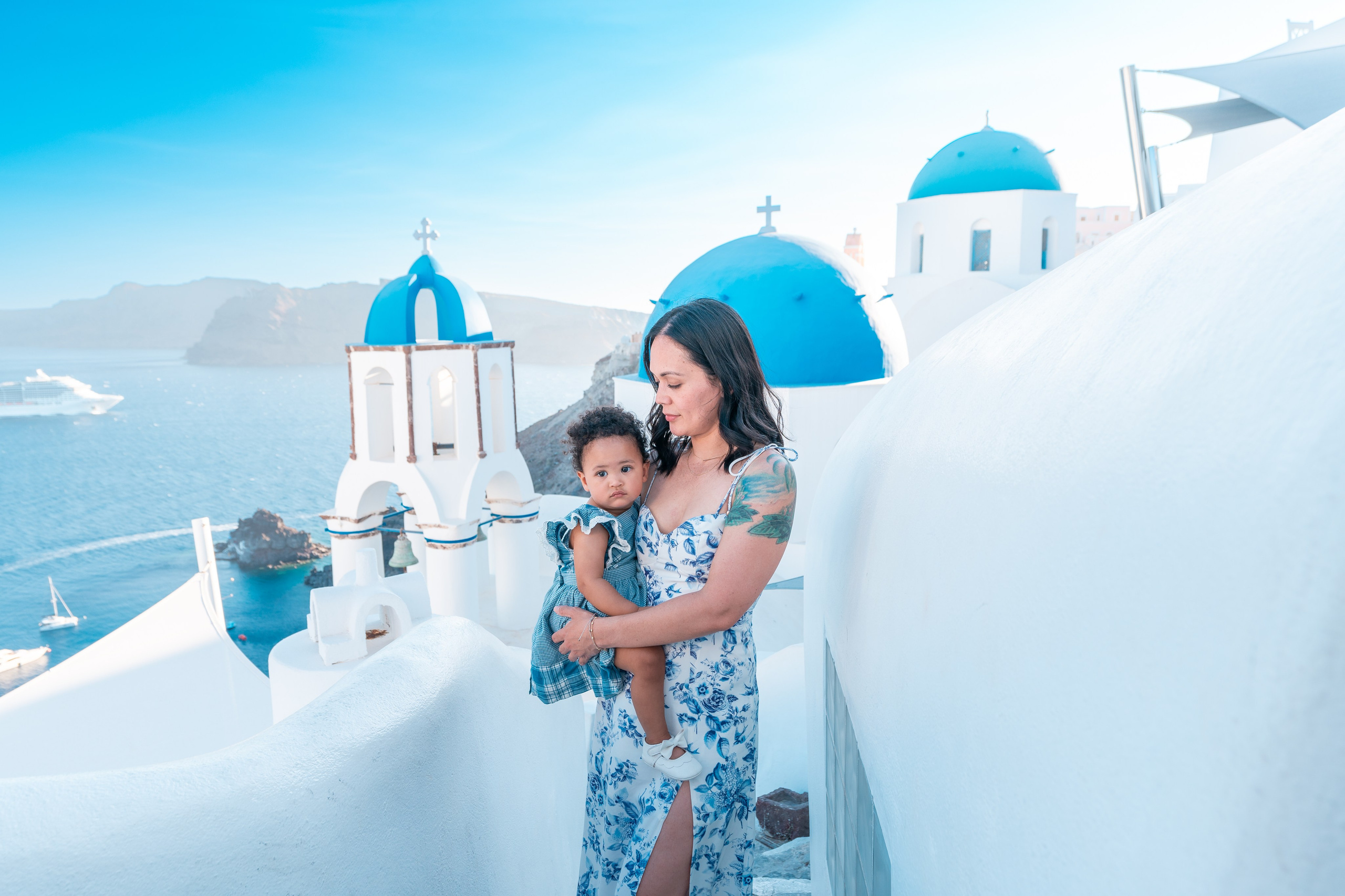"Preserve your Santorini holiday memories with a professional family photoshoot. Let the island’s iconic blue domes and scenic cliffs provide a dreamy backdrop for your portraits."