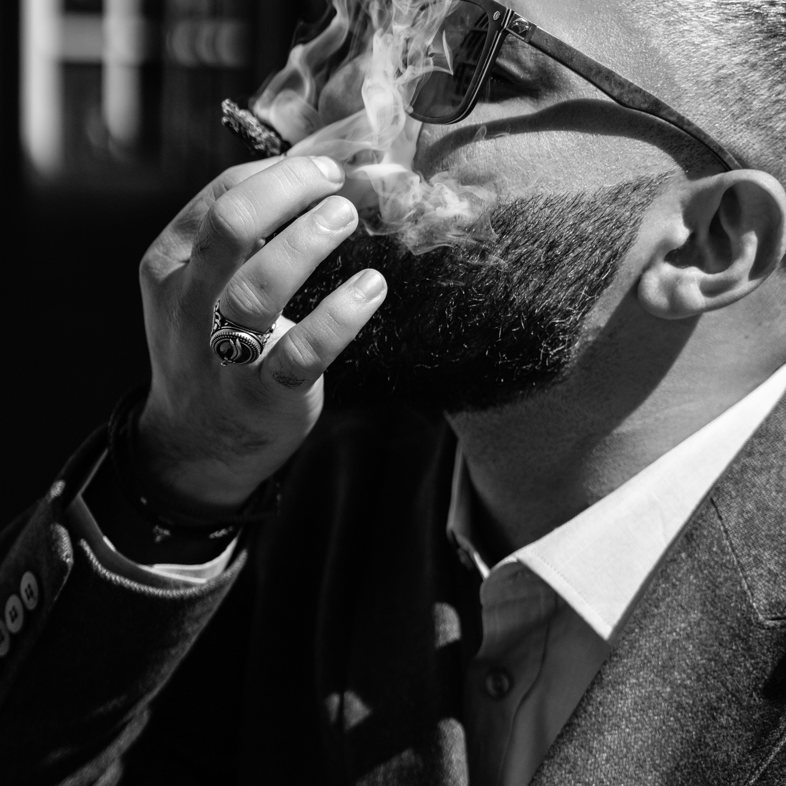 A stylish person smoking a cigar in a classic suit, showcasing an elegant lifestyle