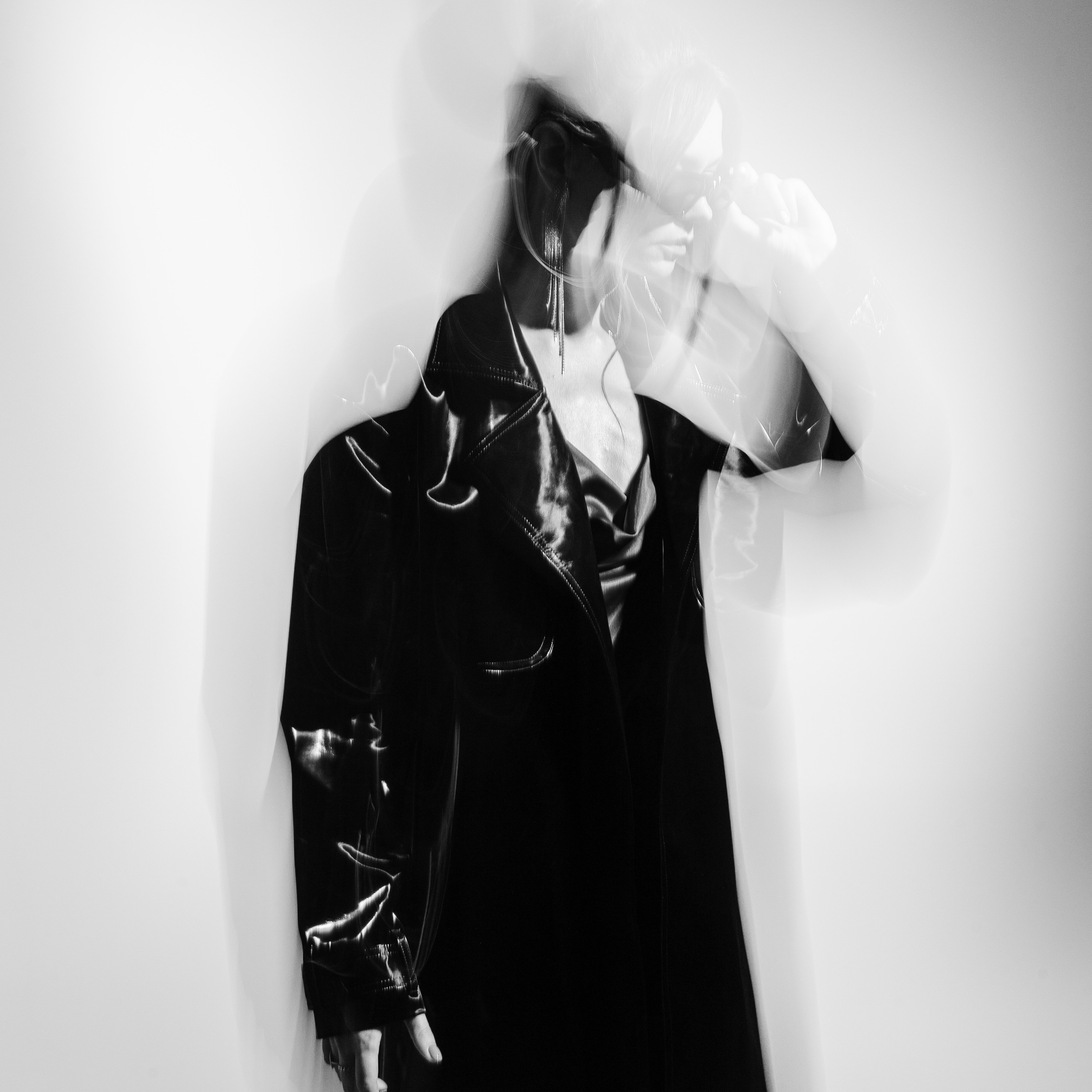 Woman in shiny black outfit with abstract blur effect, portraying motion