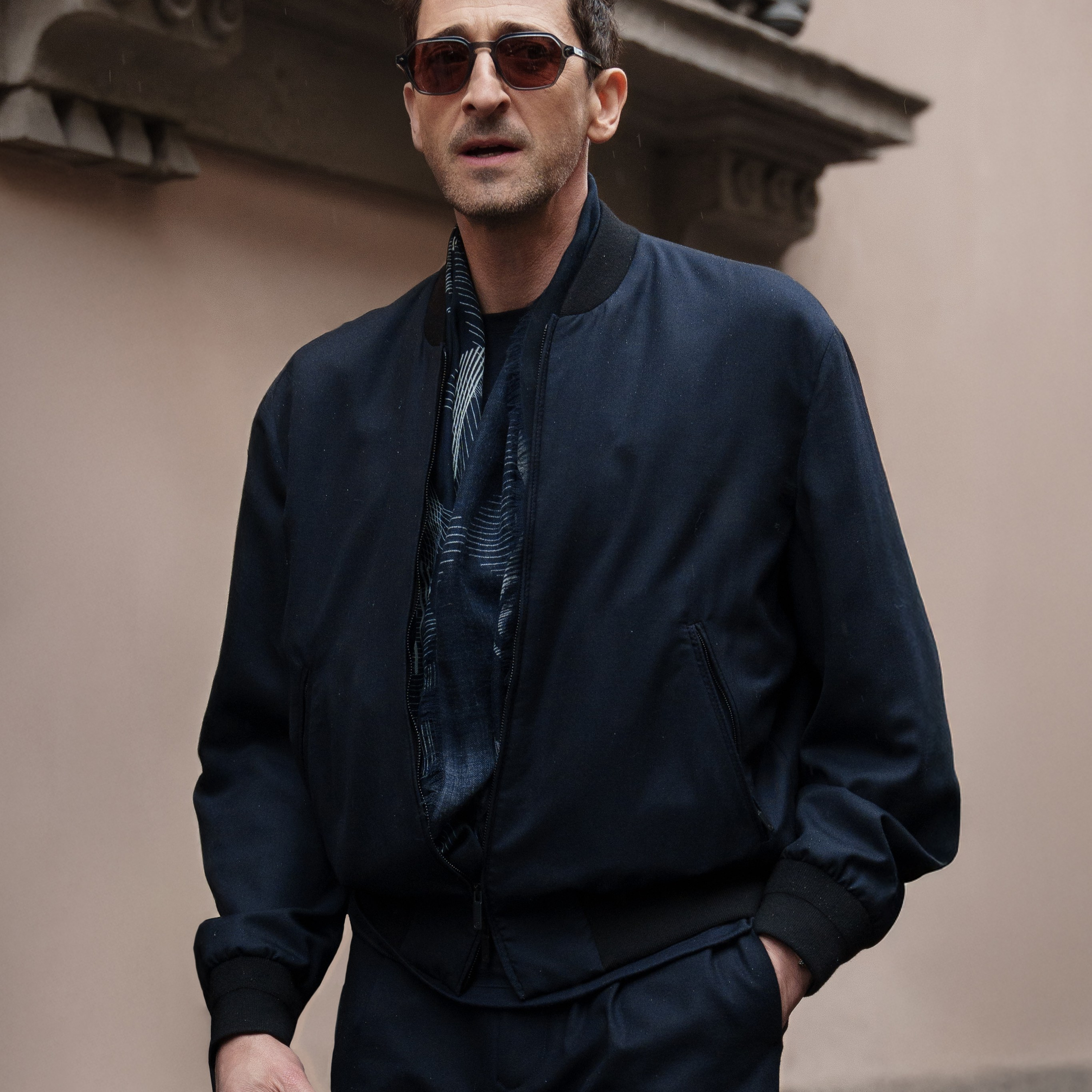 Milan Fashion Week street style photographer captures a celebrity in a navy outfit with sunglasses on the streets of Milan