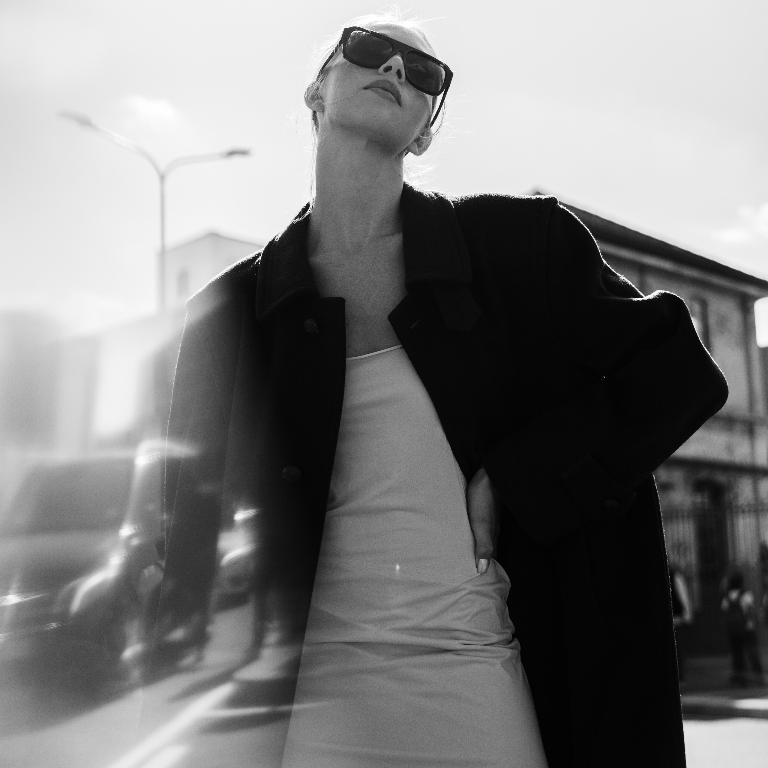 Stylish woman in a monochrome outfit with a blurred glass reflection effect in the foreground