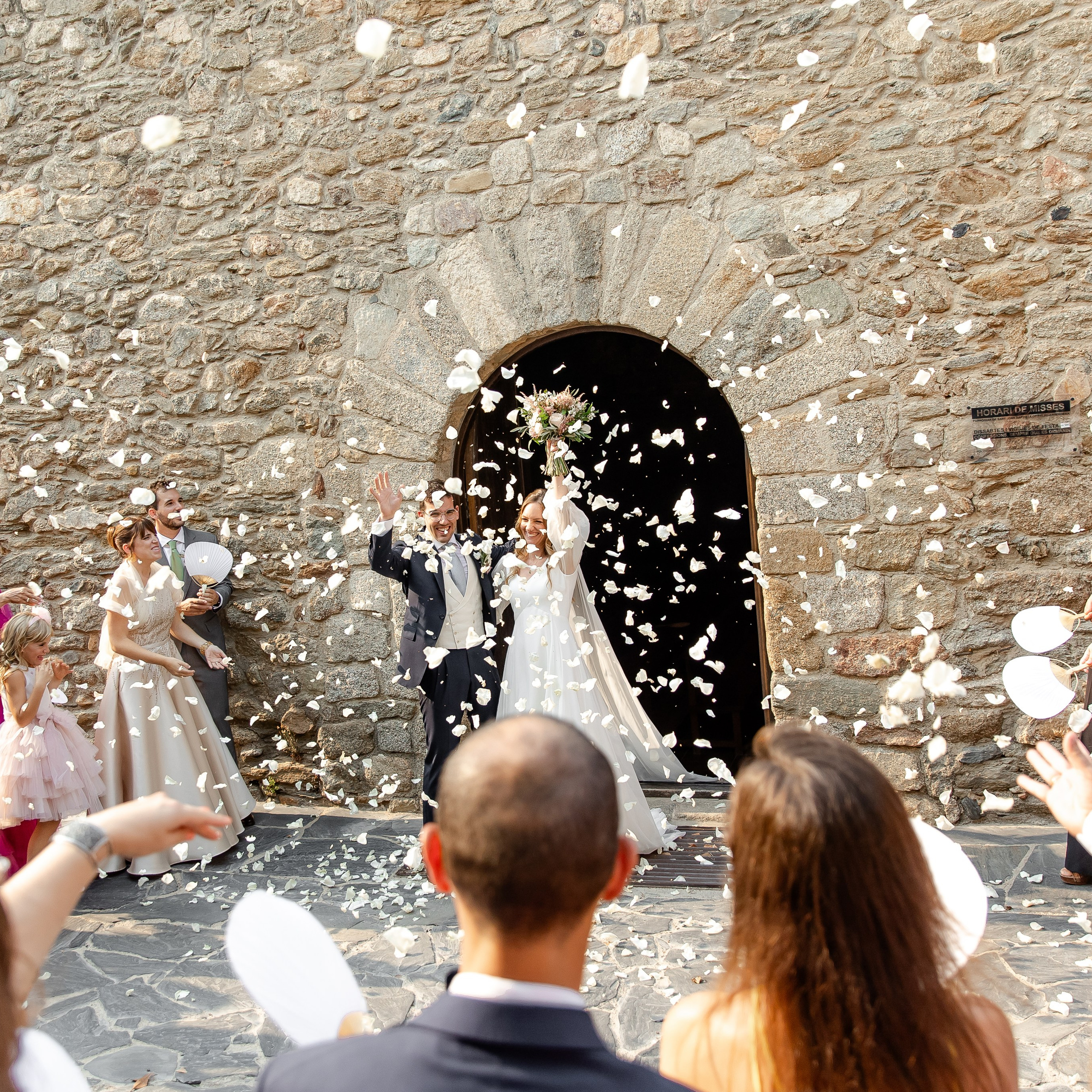 Newlyweds are leaving the church after the ceremony, surrounded by guests