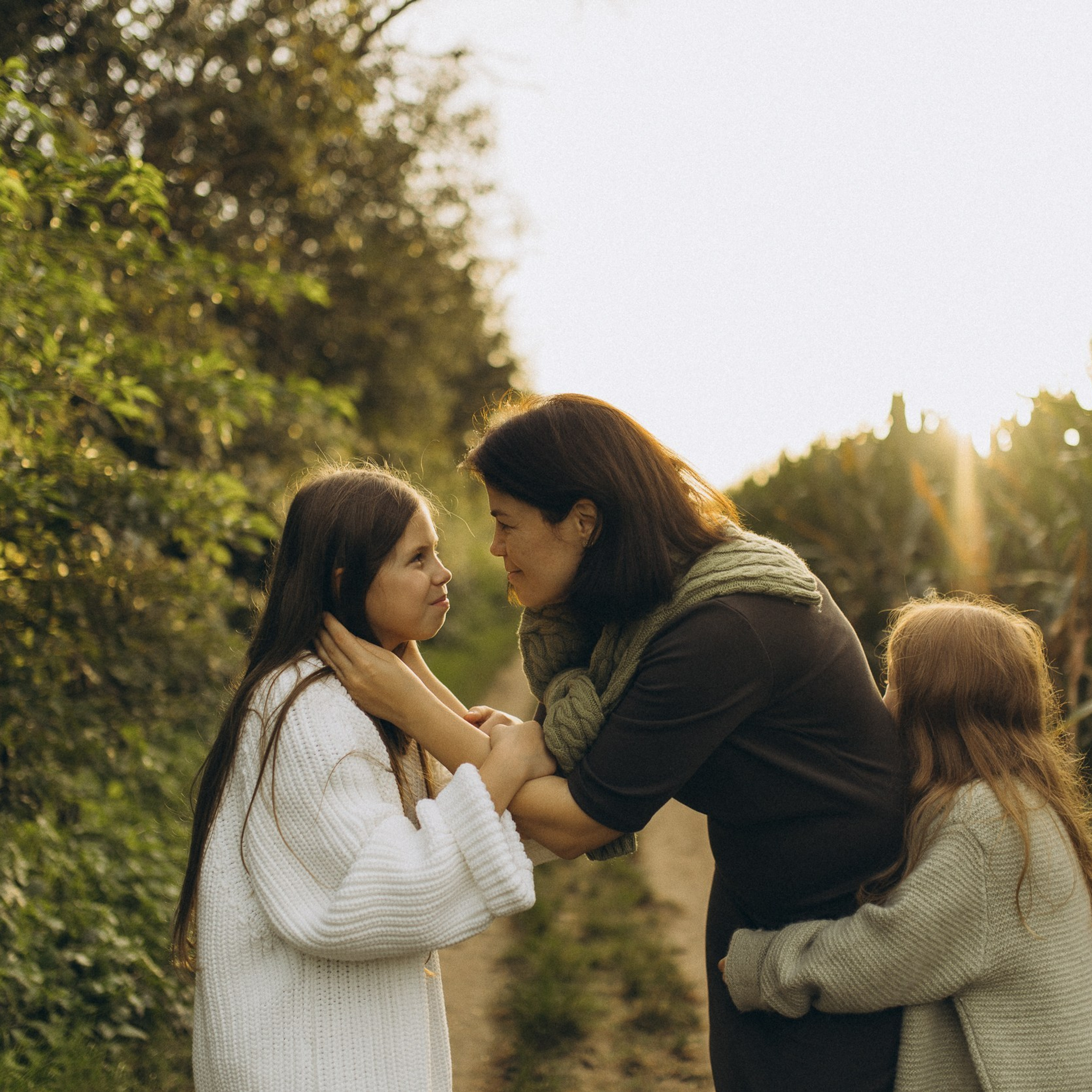 Mama und ihre zwei bezaubernden Töchter in einer familiären Fotosession