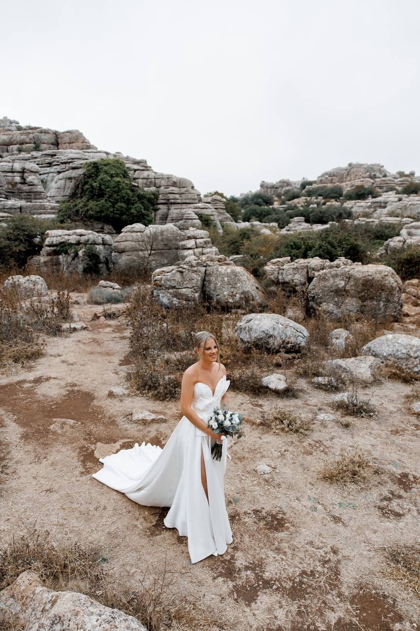 The bride walking to the groom at the wedding ceremony between the rocks
