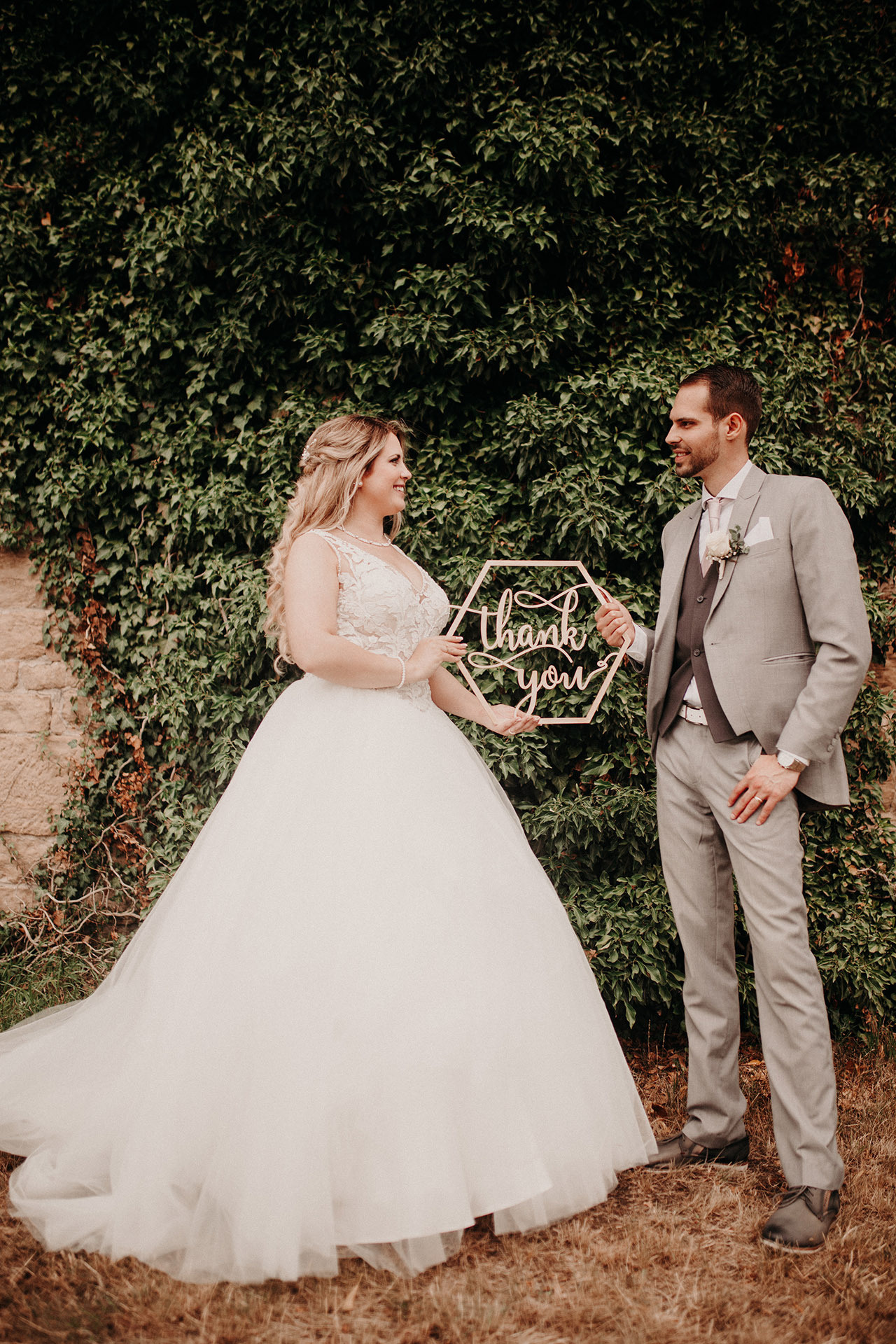 Braut und Bräutigam stehen in einem grünen Garten – romantische Hochzeitsfotografie in Karlsruhe
