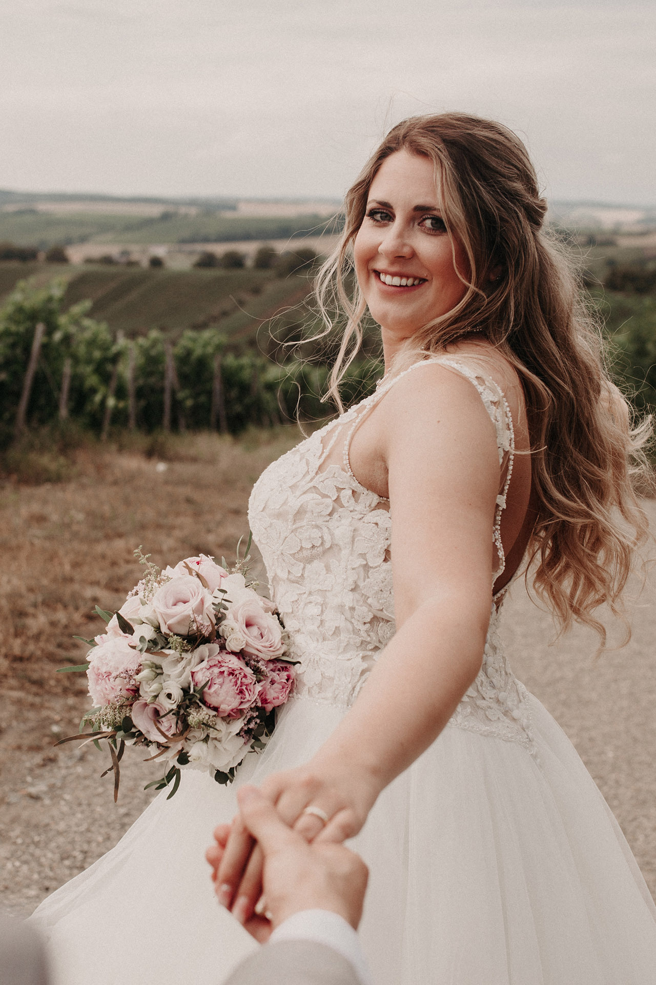 Strahlende Braut mit Blumenstrauß – emotionale Hochzeitsbilder im Freien