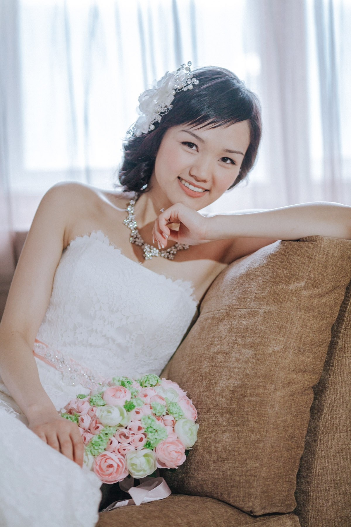 A modern portrait of the elegant Hong Kong bride as she poses with her bouquet in her luxury suite in Prague.