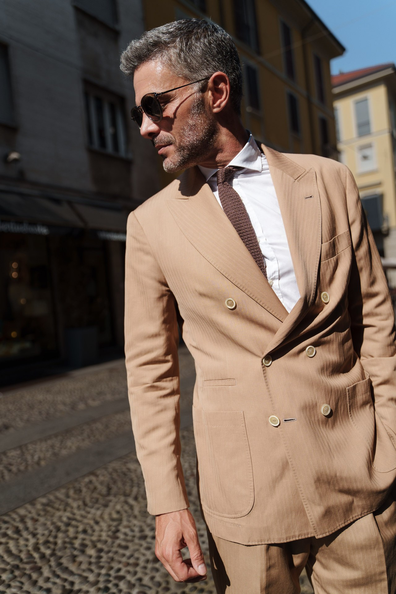 Male model in beige double-breasted suit walking in Milan