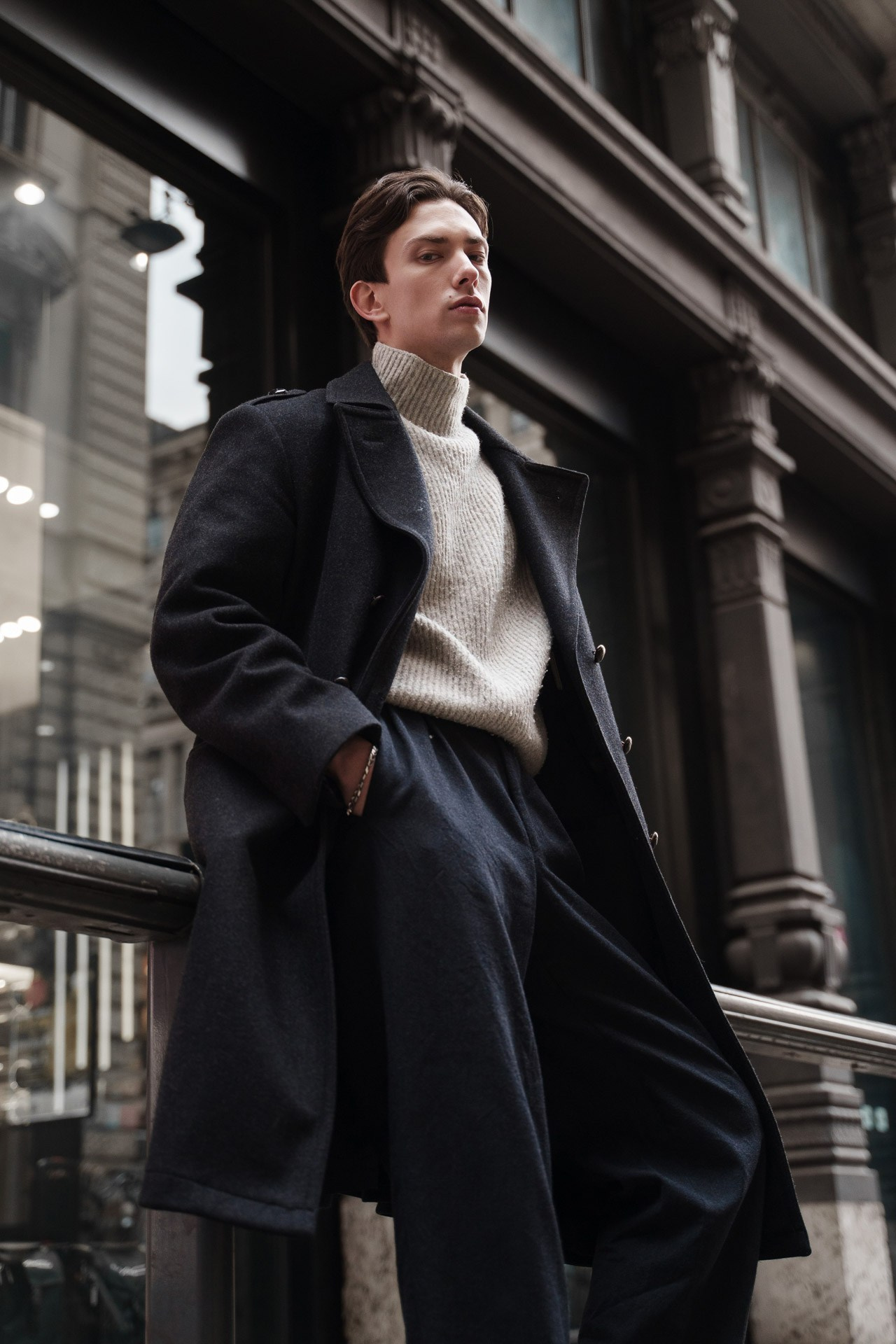 Male model in a long dark coat during a fashion test shoot in Milan