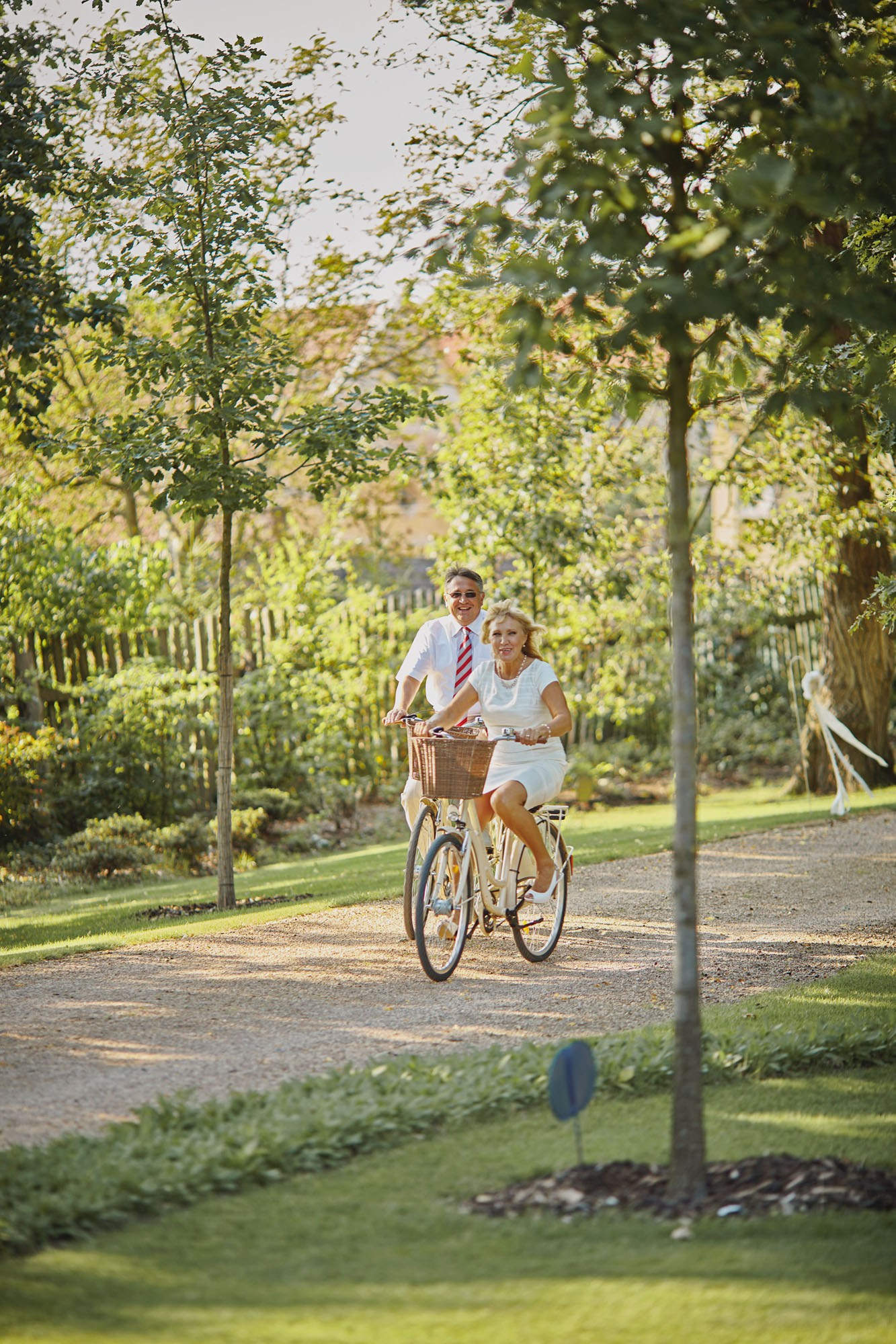 Groom's parents biking through Chateau Mcely grounds post-wedding.