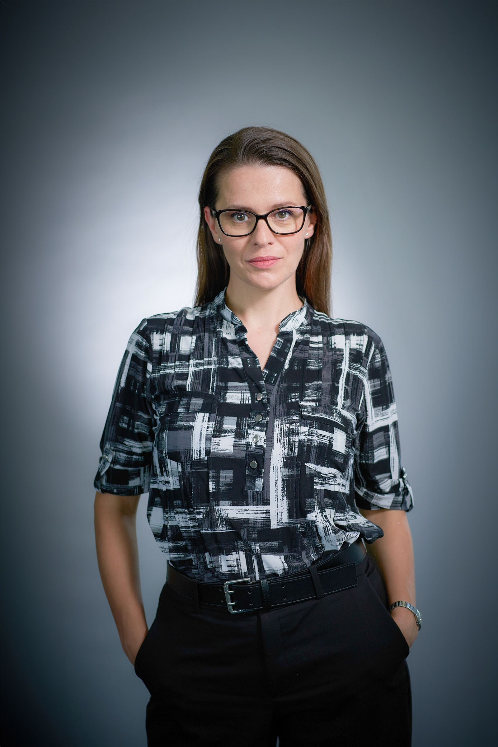 Executive headshot against gray backdrop, on-location.