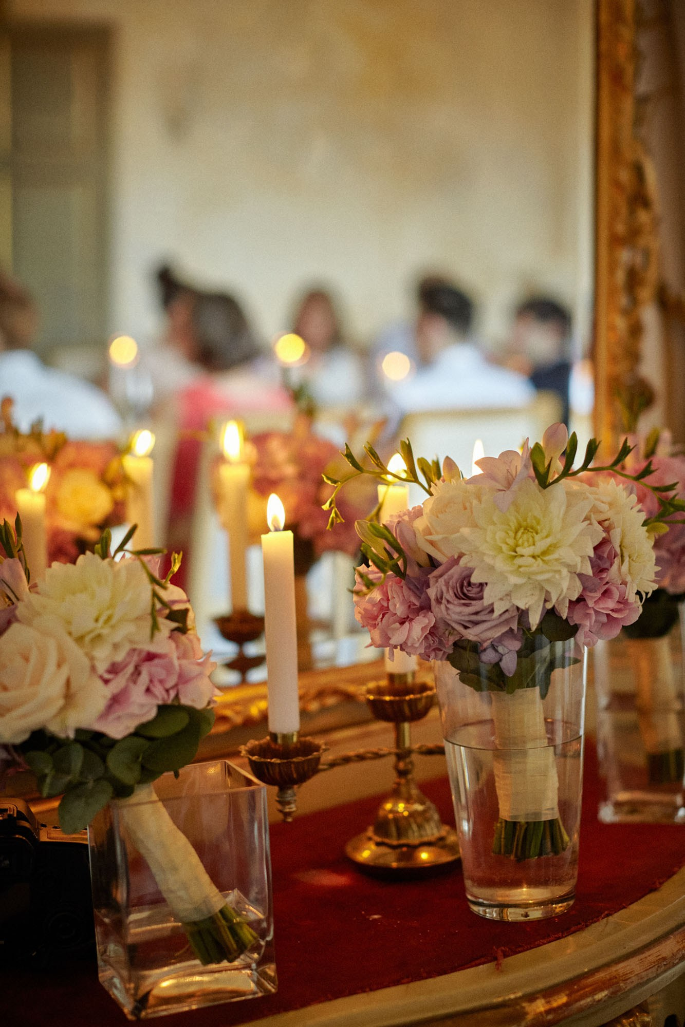 Candles and flowers procide a stylish and opulent atmosphere for the gathered wedding party as they enjoy a dinner at the Chateau Mcely.