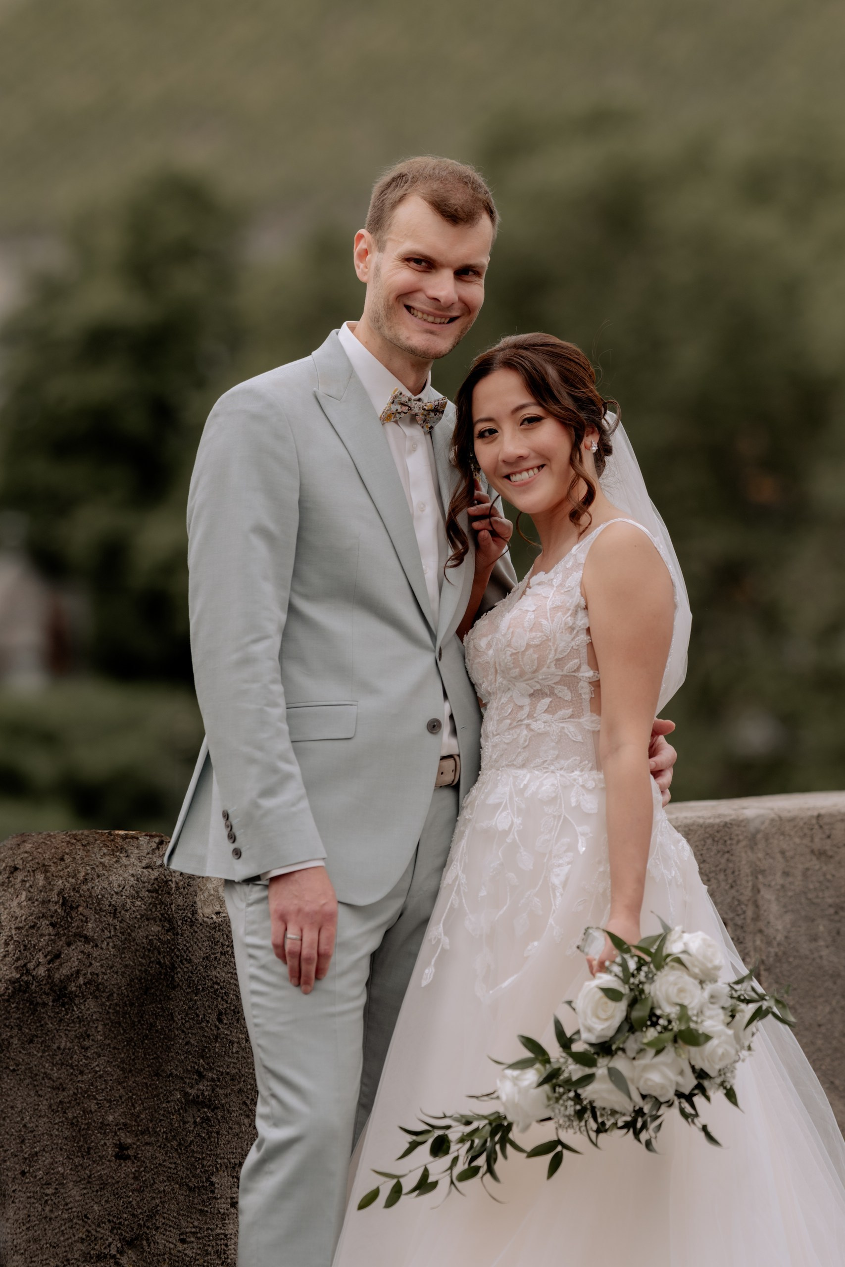 raut und Bräutigam halten sich an den Händen und lachen sich liebevoll an, im Hintergrund die Altstadt von Würzburg bei goldenem Abendlicht.